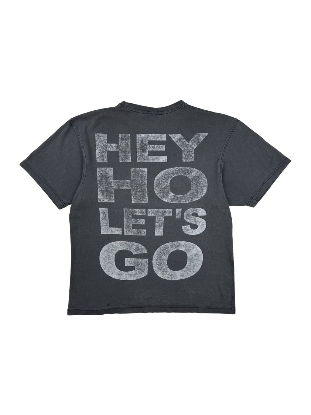 Rückansicht des grauen Vintage Ramones T-Shirts im Flatlay. Aufgedruckt ist der ikonische Songtext-Slogan „HEY HO LET'S GO“ in großen, weißen Blockbuchstaben mit starker Vintage-Patina.