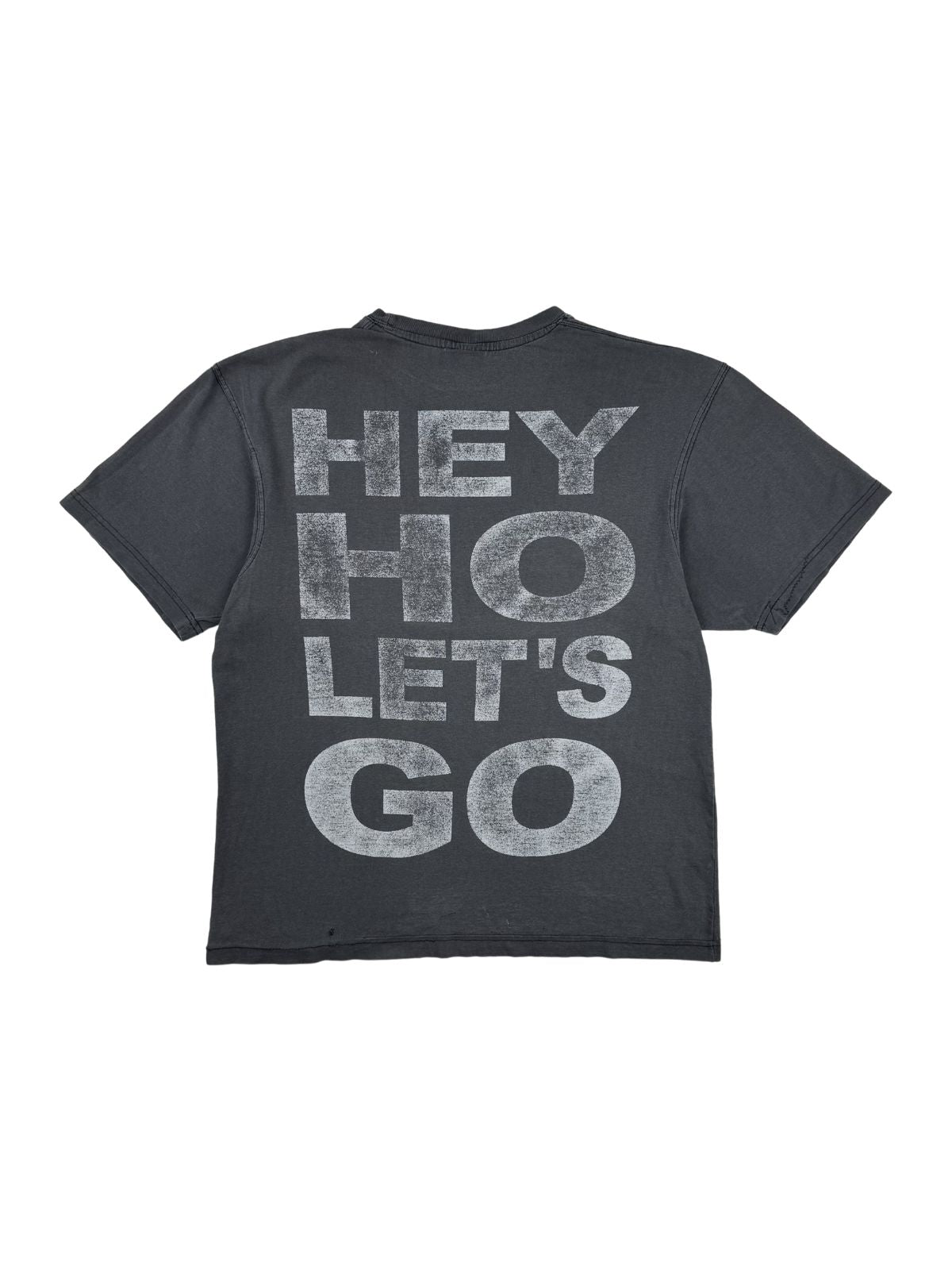 Rückansicht des grauen Vintage Ramones T-Shirts im Flatlay. Aufgedruckt ist der ikonische Songtext-Slogan „HEY HO LET'S GO“ in großen, weißen Blockbuchstaben mit starker Vintage-Patina.