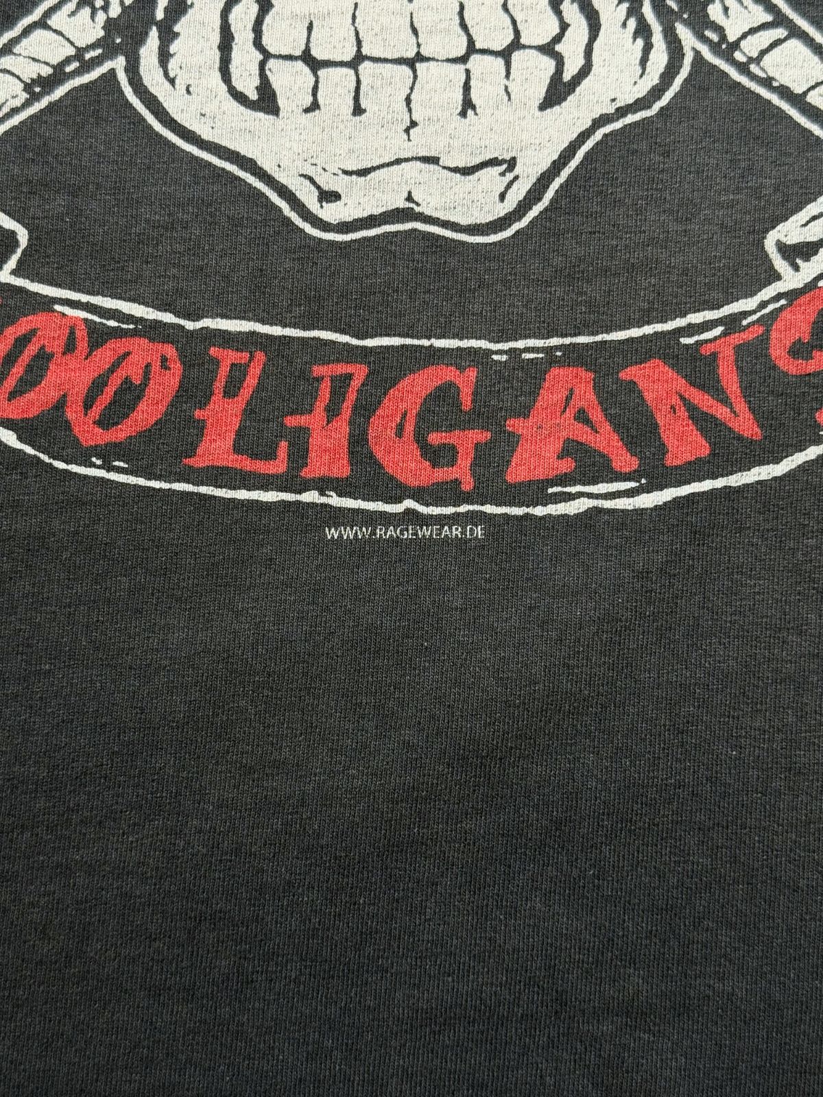 Makroaufnahme des unteren Print-Randes mit dem aufgedruckten Webseiten-Verweis „WWW.RAGEWEAR.DE“.