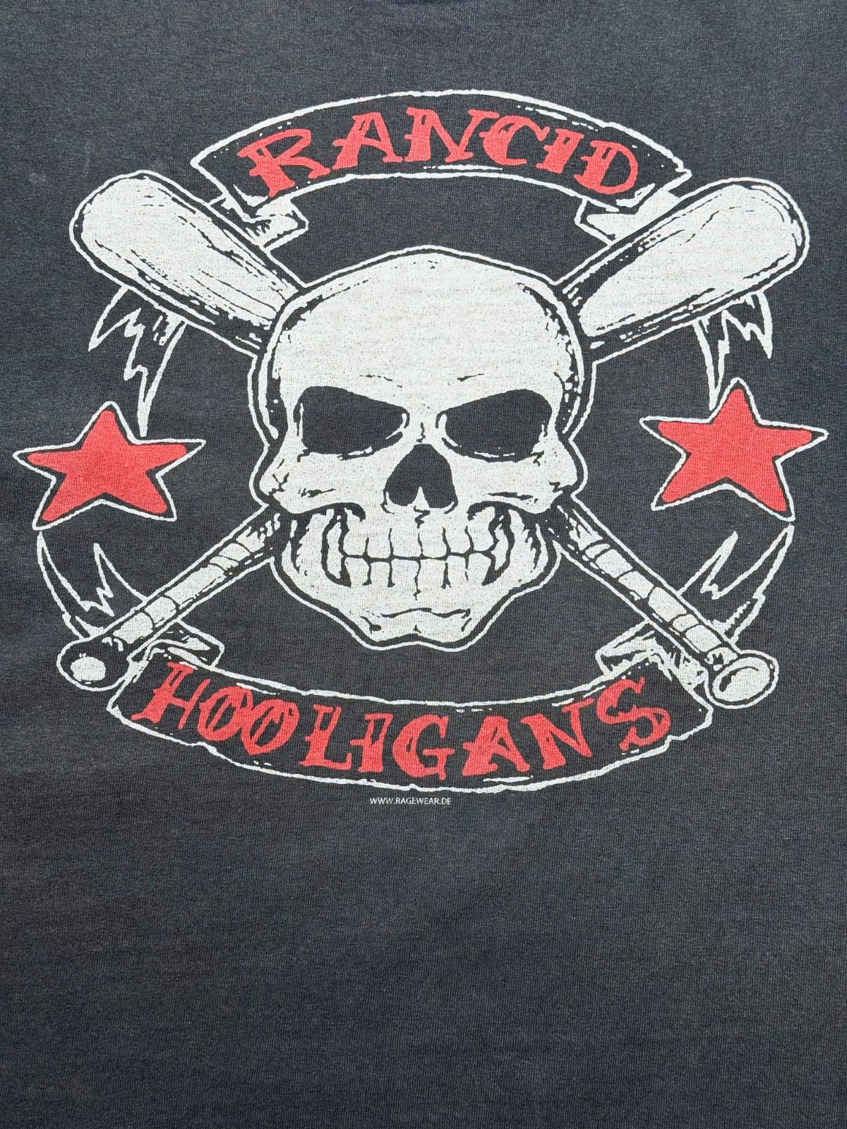 Detailansicht des vorderen Siebdrucks mit dem kreisförmigen Emblem: Totenkopf, gekreuzte Baseballschläger, zwei rote Sterne sowie die Schriftzüge „RANCID“ und „HOOLIGANS“.