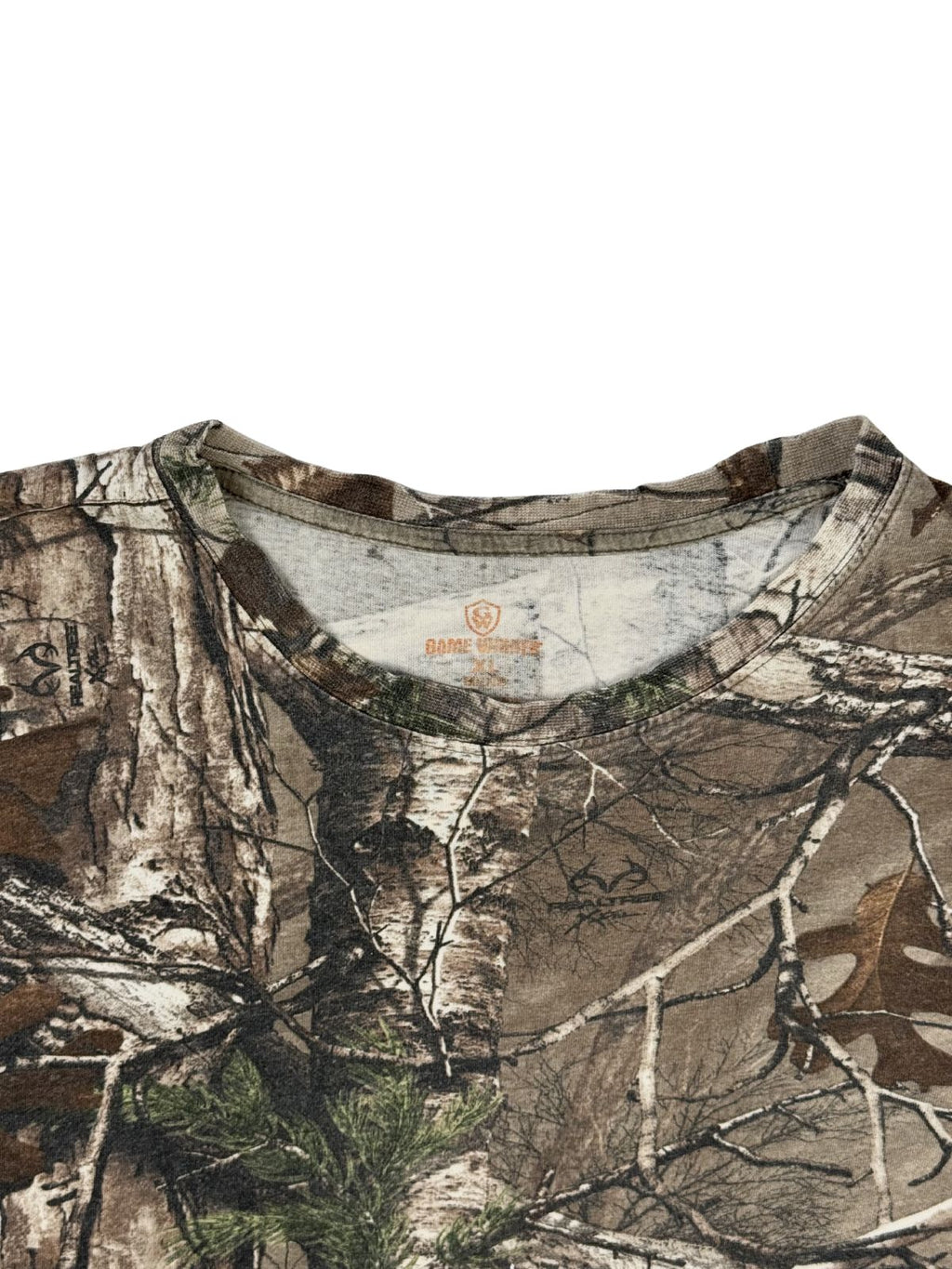 Detailansicht des Rundhalsausschnitts auf der Vorderseite des Realtree Camouflage T-Shirts mit Blick auf den orangefarbenen Nackendruck.