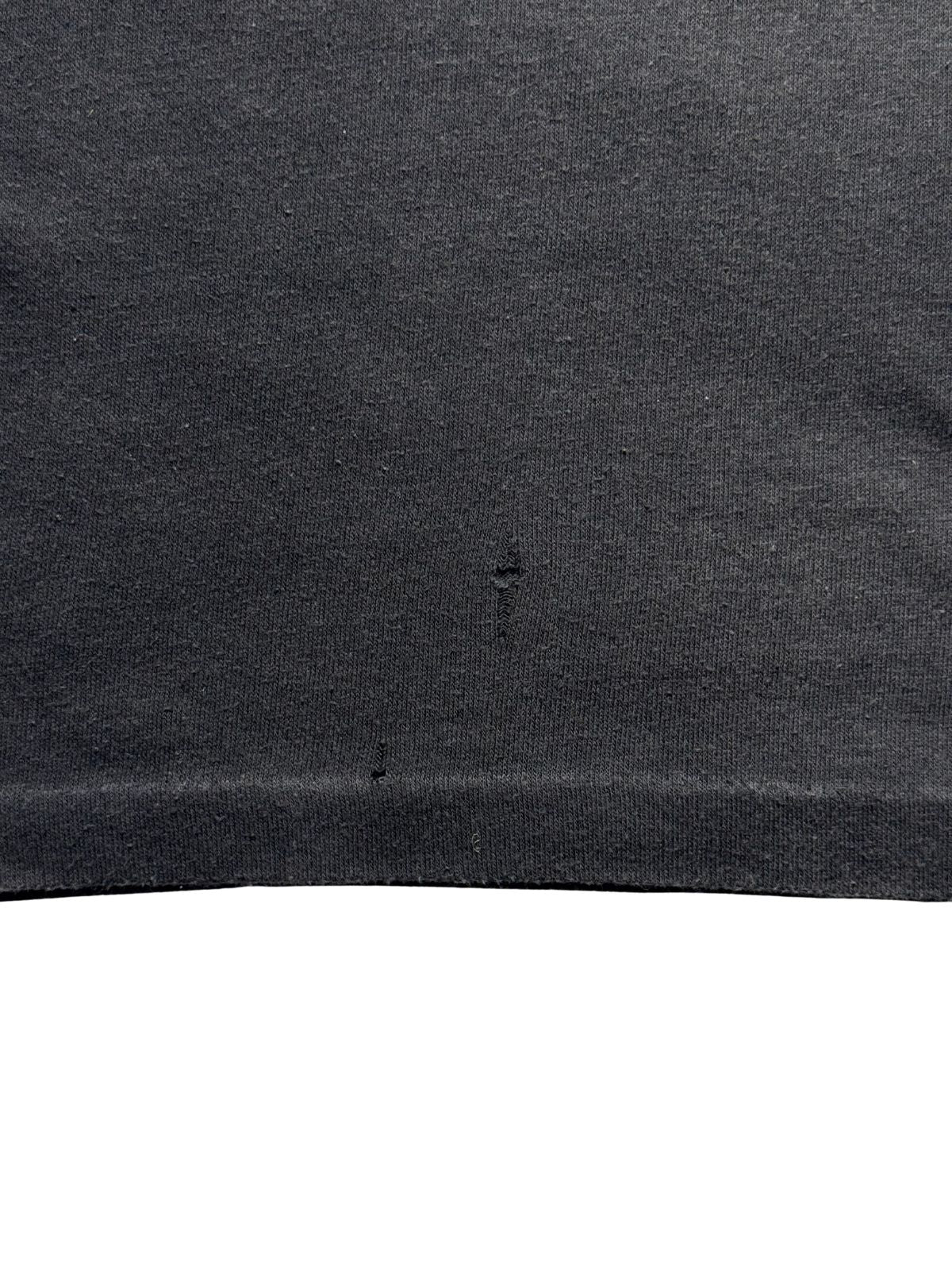 Nahaufnahme des Stoffes zur transparenten Zustandsdokumentation von zwei feinen Pinholes (kleinen Löchern) im Baumwollmaterial.