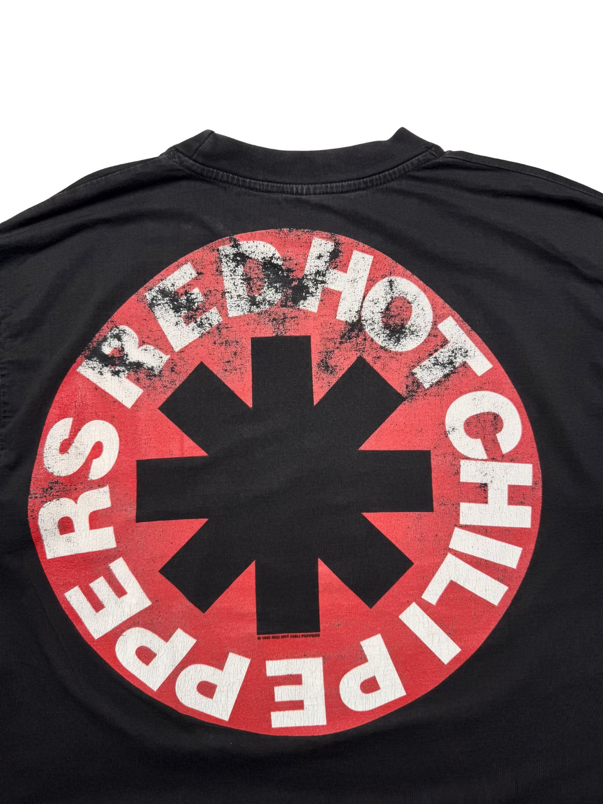 Detaillierte Ansicht des oberen Rückenprints mit dem kreisförmigen, rot-weißen „RED HOT CHILI PEPPERS“-Sternenlogo.