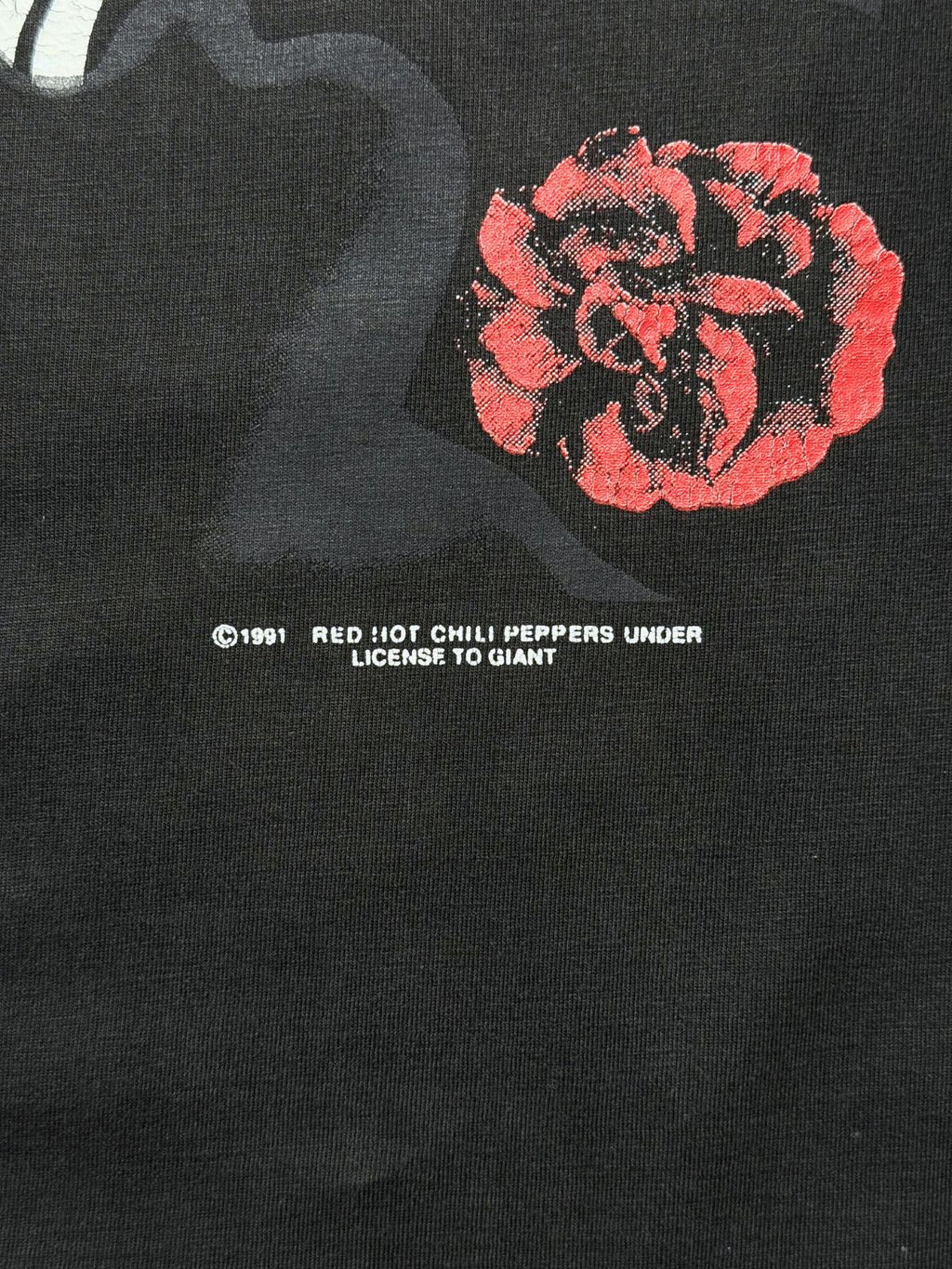 Makroaufnahme der Front-Lizenzzeile neben der gesiebdruckten Rose: „© 1991 RED HOT CHILI PEPPERS UNDER LICENSE TO GIANT“.