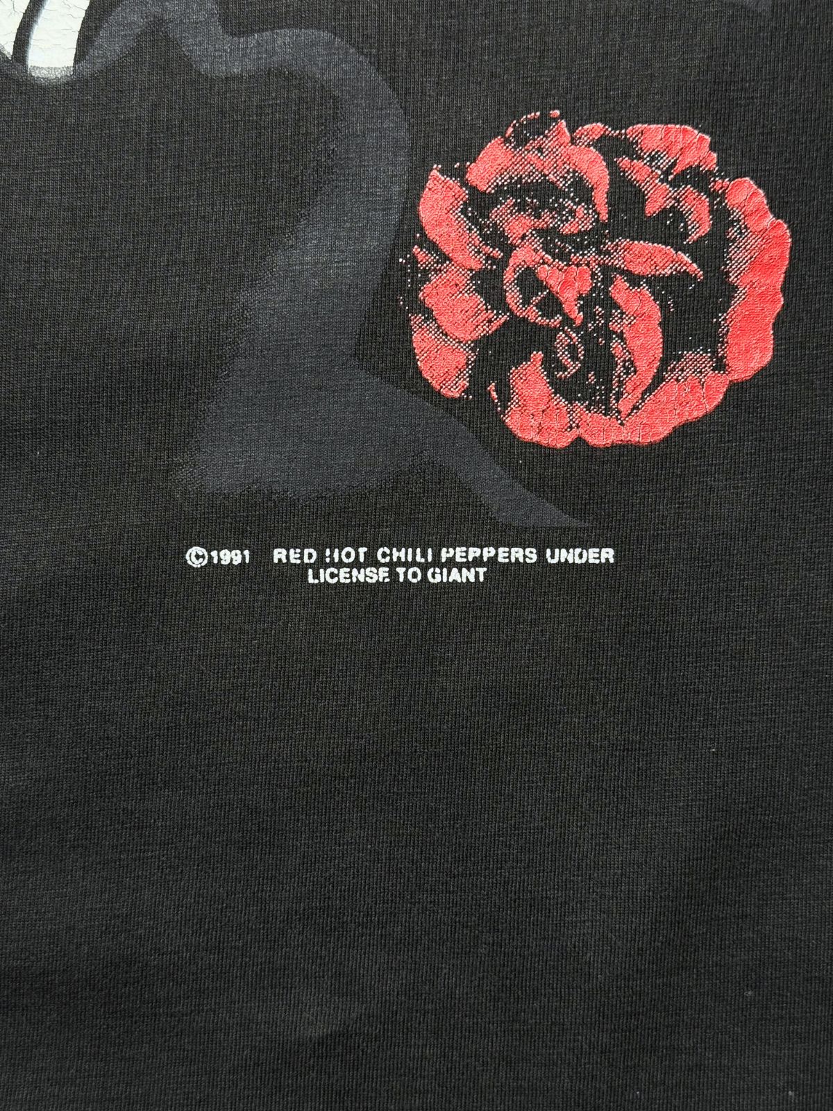 Makroaufnahme der Front-Lizenzzeile neben der gesiebdruckten Rose: „© 1991 RED HOT CHILI PEPPERS UNDER LICENSE TO GIANT“.
