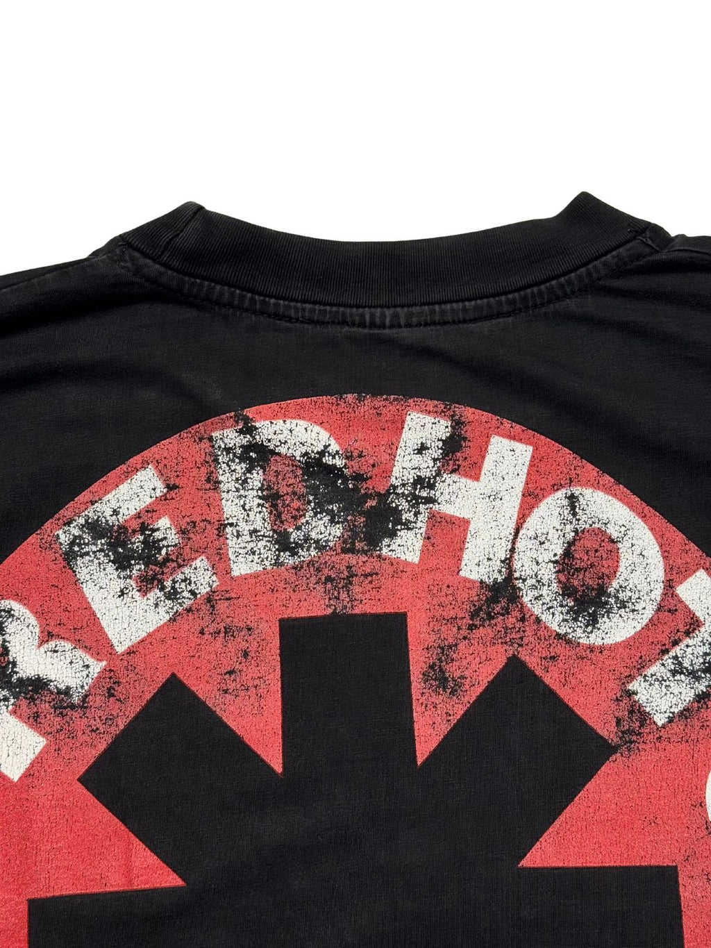 Detailansicht der hinteren Kragennaht mit Blick auf das leicht rissige, rot-weiße Asterisk-Logo der Red Hot Chili Peppers.