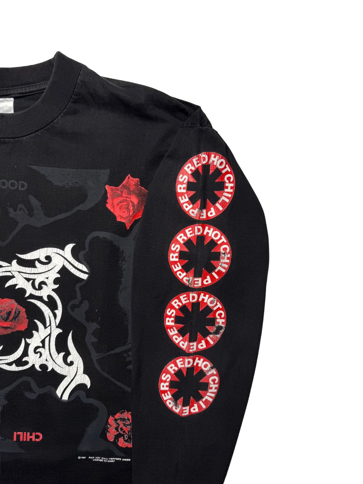 Nahaufnahme des linken Ärmels mit vier untereinander gedruckten, rot-weißen „RED HOT CHILI PEPPERS“-Sternenlogos.