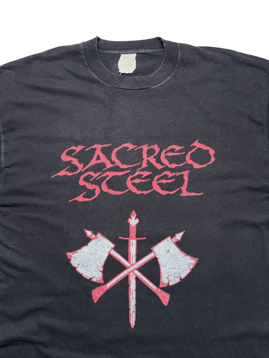 Detailansicht der vorderen Brustpartie mit geripptem Rundhalsausschnitt, rotem „SACRED STEEL“-Logo, gekreuzten Streitäxten und Schwert-Grafik.