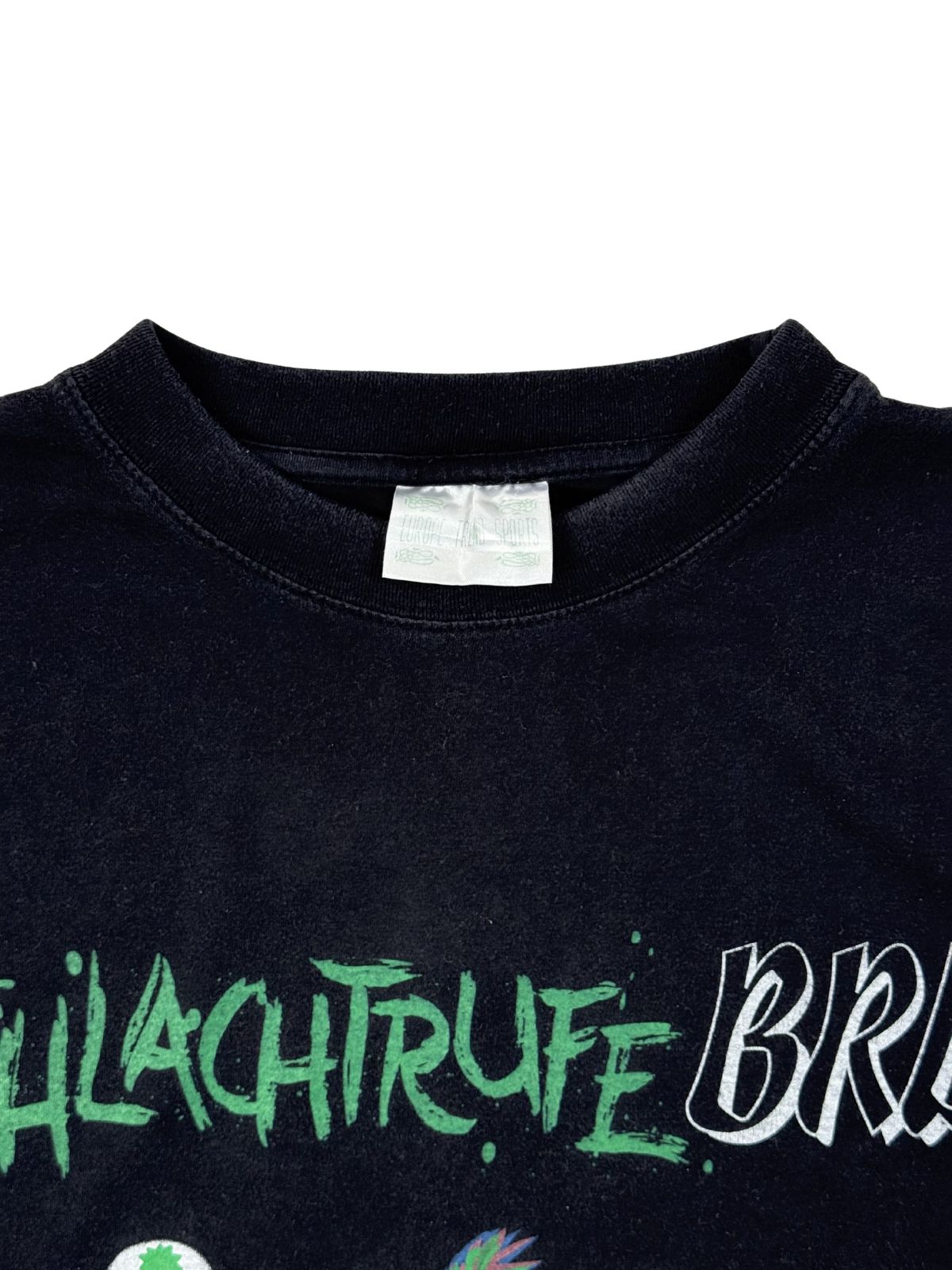 Nahaufnahme des Rundhalsausschnitts auf der Vorderseite mit Blick auf das originale, weiße Textiletikett (Europe Team Sports) im Kragen über dem grünen Print-Schriftzug.