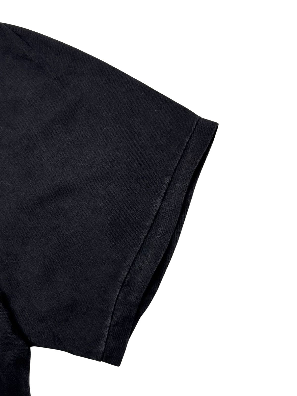 Detailansicht des kurzen Ärmelbunds mit echten Vintage-Single-Stitch-Nähten auf dem verwaschenen schwarzen Baumwollstoff.