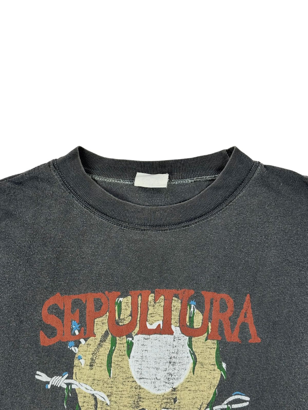 Detailansicht des Rundhalsausschnitts auf der Vorderseite mit Blick auf den roten, klassischen Sepultura-Schriftzug und ein stark verwaschenes, weißes Kragenetikett.