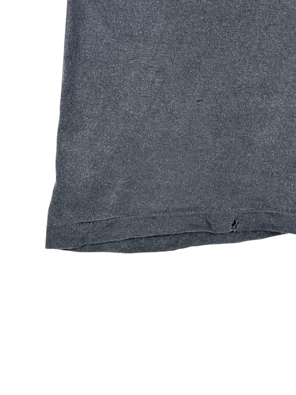 Nahaufnahme des unteren Bunds mit Single Stitch Naht, die eine kleine Beschädigung (Loch) im gealterten Baumwollstoff zeigt.