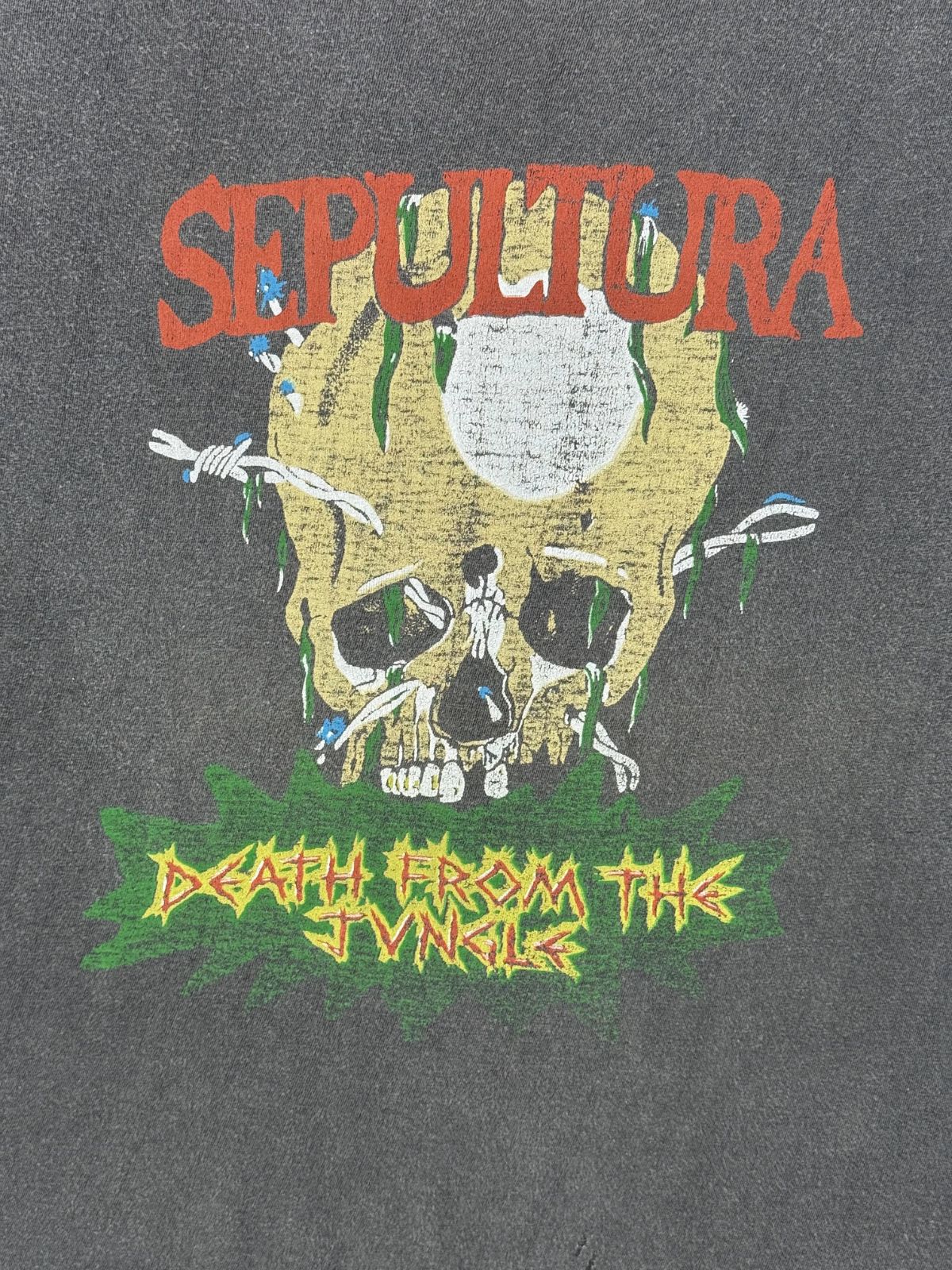 Nahaufnahme des vorderen Siebdrucks mit einem von Stacheldraht umwickelten Totenkopf, Lianen und dem giftgrün unterlegten Schriftzug „DEATH FROM THE JUNGLE“.