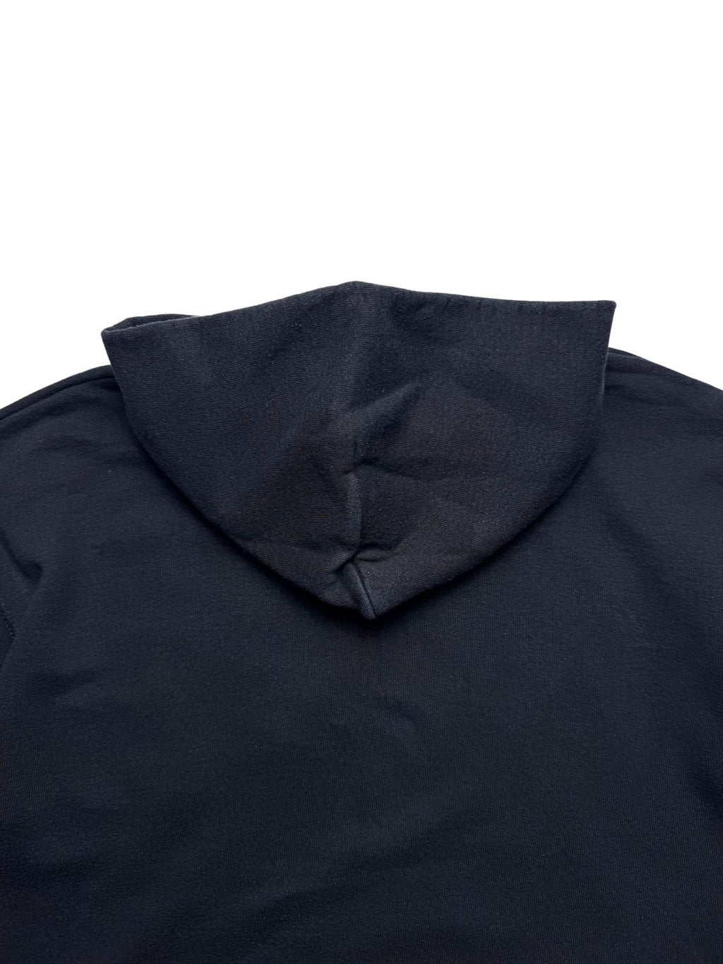 Detailansicht der oberen Rückseite unterhalb des Kapuzenansatzes auf verwaschenem schwarzen Sweatshirt-Stoff.