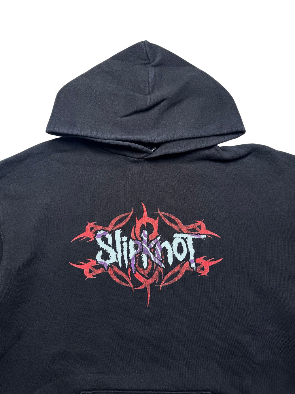 Detailansicht der vorderen Brustpartie unterhalb der Kapuze mit dem rot-lila „Slipknot“-Schriftzug über dem Tribal-Muster und Tribal-S-Logo.