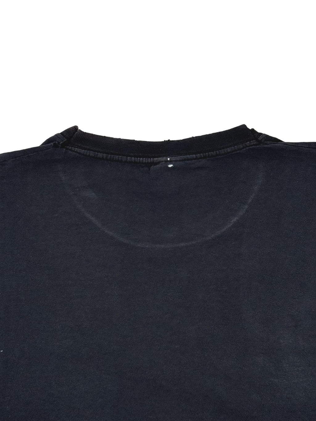 Detailaufnahme der Nackenpartie auf der Rückseite des verwaschenen Baumwollshirts mit leichten Tragespuren.