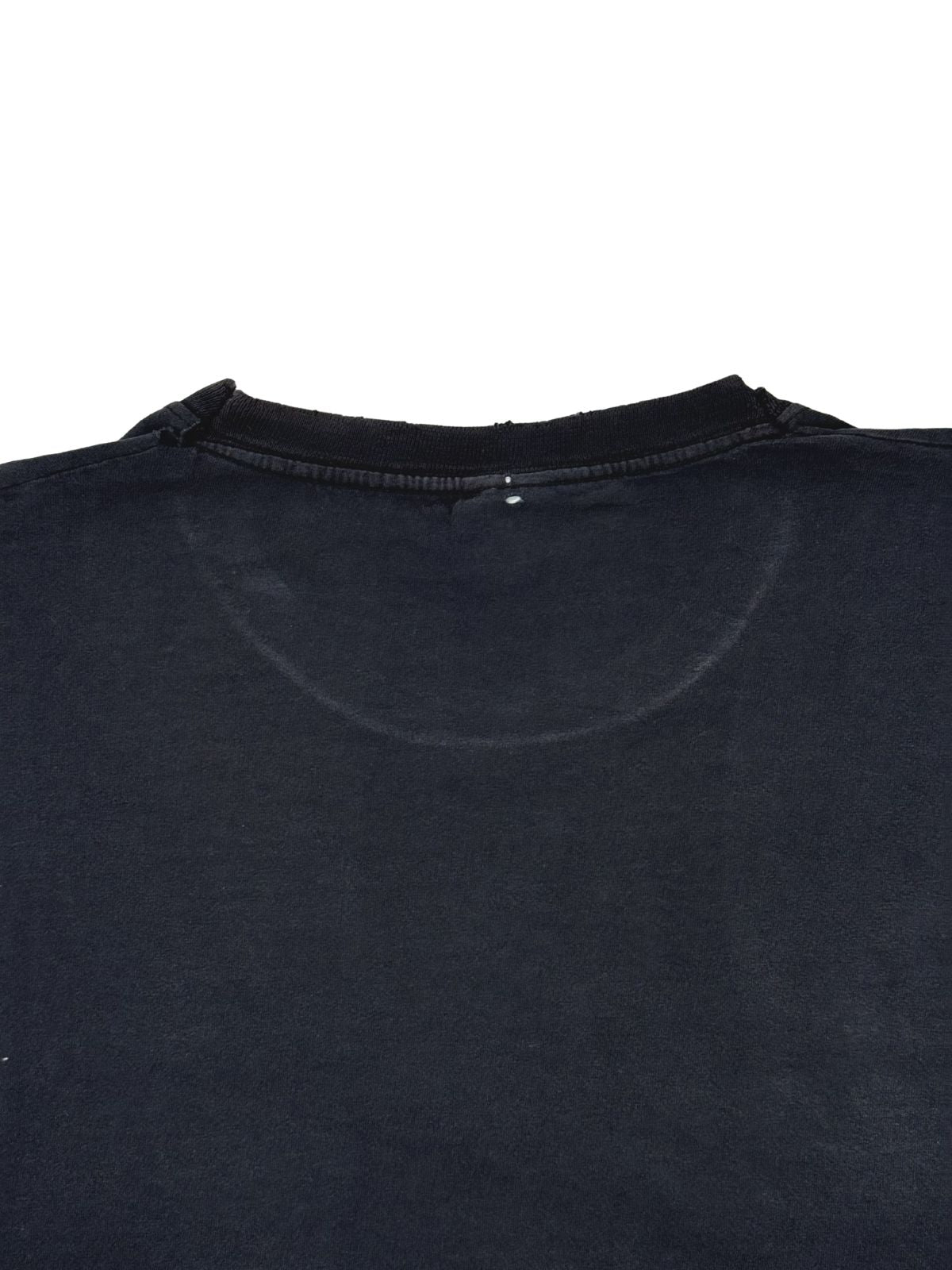 Detailaufnahme der Nackenpartie auf der Rückseite des verwaschenen Baumwollshirts mit leichten Tragespuren.