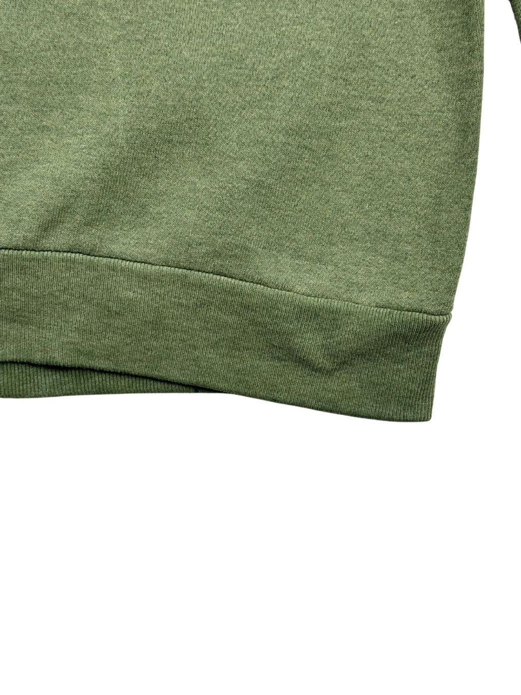 Nahaufnahme des breiten, elastischen Bunds am unteren Saum des grünen Vintage-Pullovers zur Veranschaulichung der Materialstruktur.