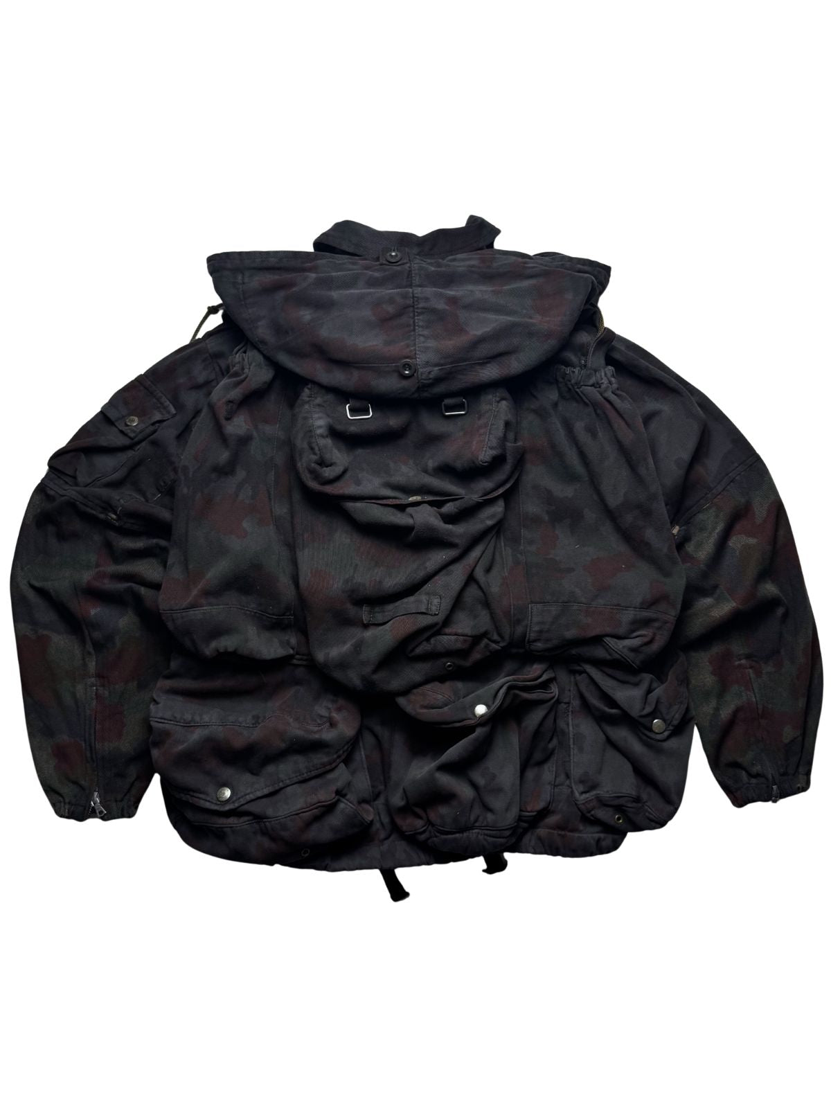 Rückansicht der Schweizer M70-Feldjacke mit integriertem, abnehmbarem Rucksack-System im Alpentarn-Camouflage.