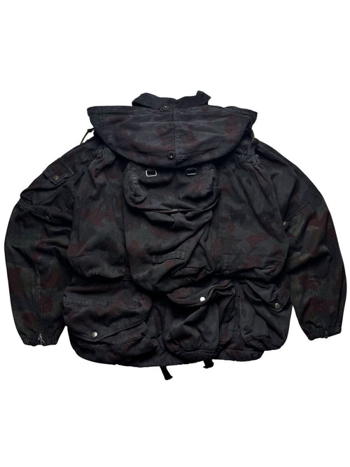 Rückansicht der Schweizer M70-Feldjacke mit integriertem, abnehmbarem Rucksack-System im Alpentarn-Camouflage.