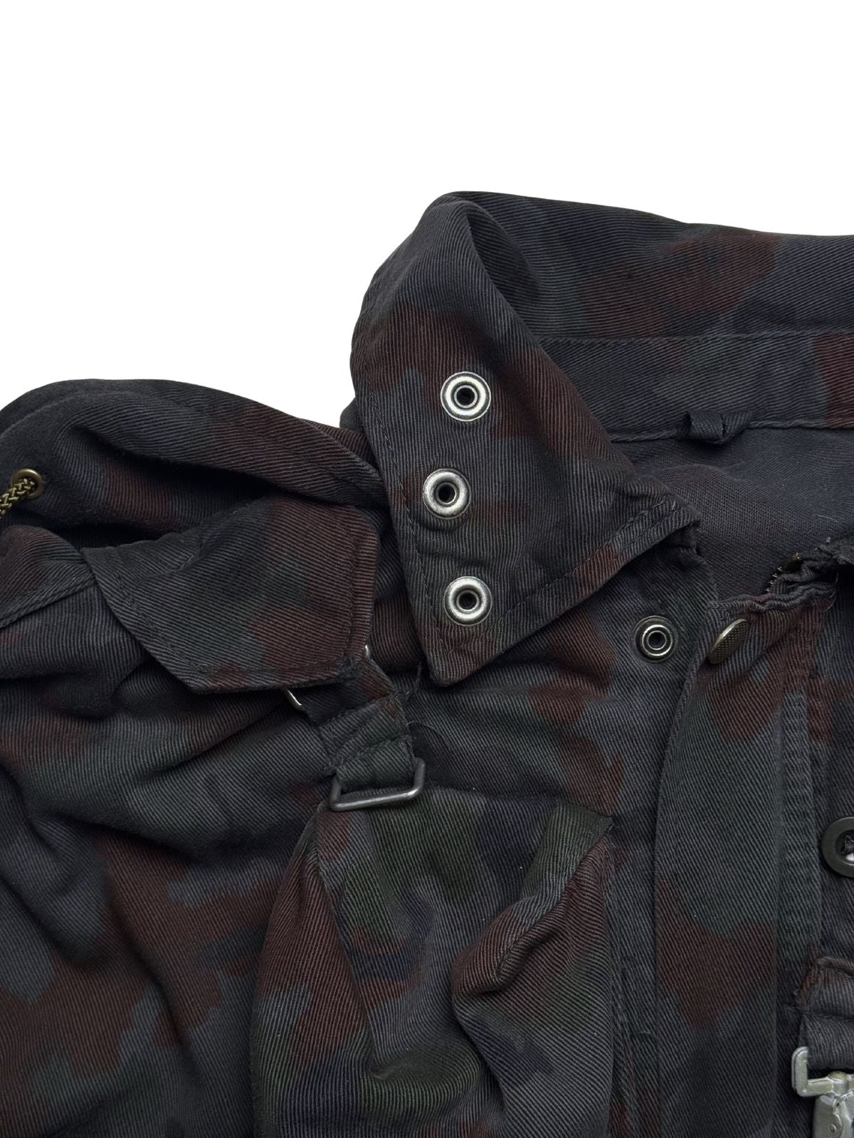 Nahaufnahme der metallenen Frontverschlüsse und Karabinerhaken an der Schweizer M70-Feldjacke, die für ihre extreme Langlebigkeit bekannt ist.