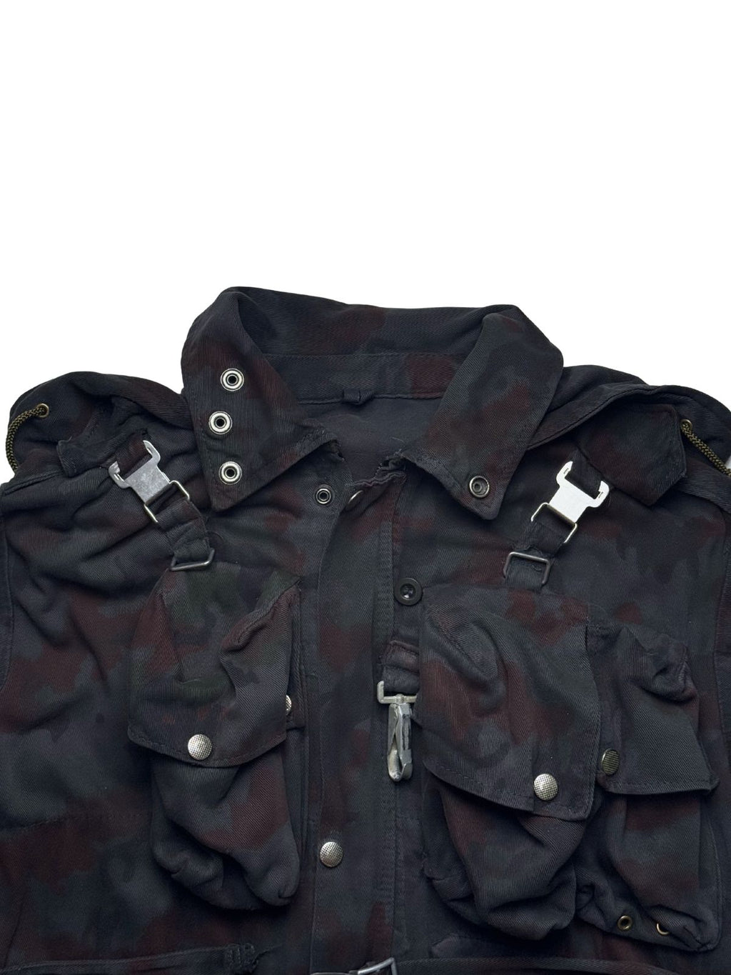 Detailaufnahme der Vorderseite der M70-Feldjacke: Fokus auf die robusten Druckknöpfe, die charakteristische Koppel-Schnalle und die aufgesetzten Fronttaschen im Alpentarn-Muster.