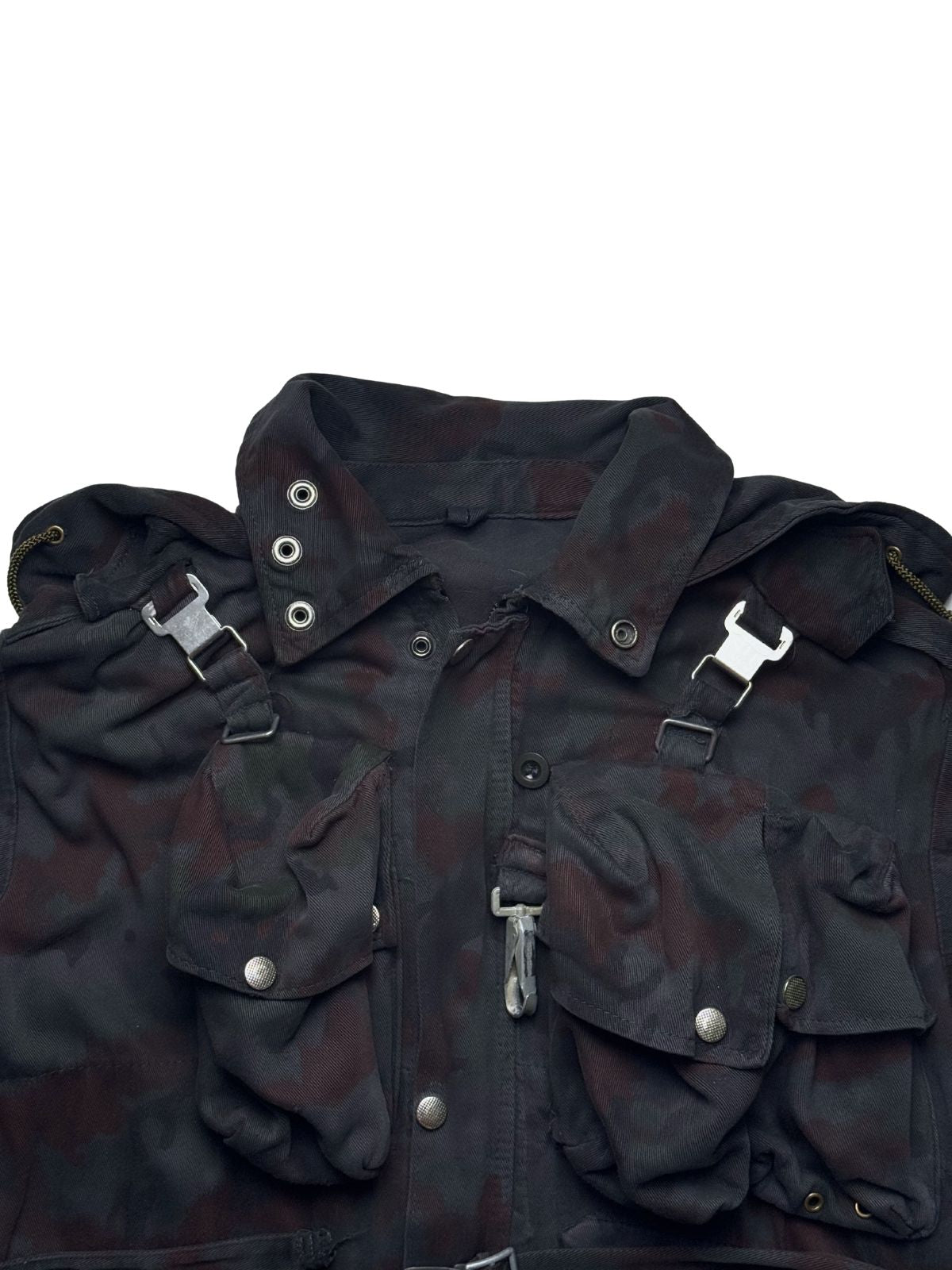 Detailaufnahme der Vorderseite der M70-Feldjacke: Fokus auf die robusten Druckknöpfe, die charakteristische Koppel-Schnalle und die aufgesetzten Fronttaschen im Alpentarn-Muster.