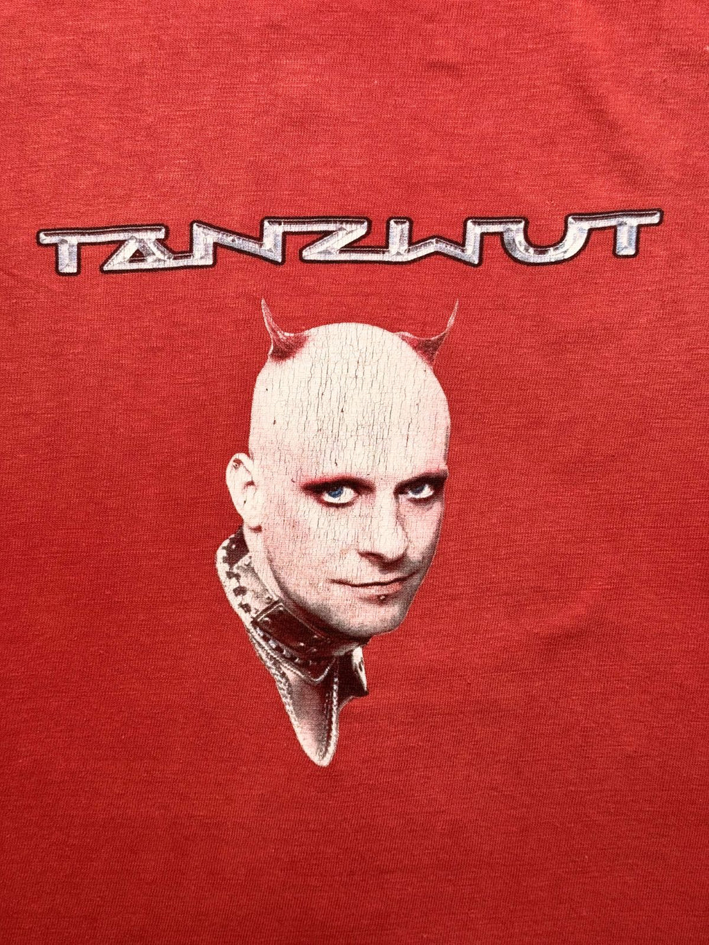 Detailansicht des vorderen Siebdrucks mit dem futuristischen „TANZWUT“-Schriftzug und dem Porträt des Frontmanns mit Teufelshörnern.