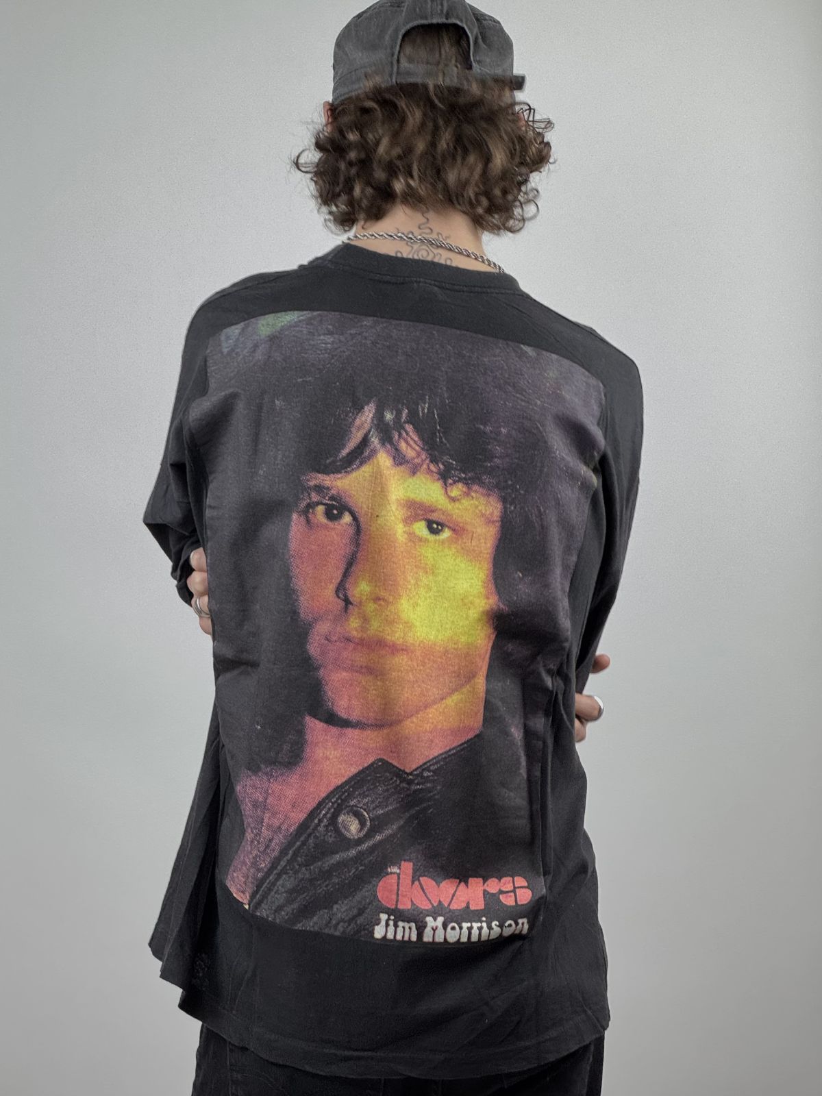 Rückansicht des getragenen The Doors Band-Shirts kombiniert mit einer schwarzen Mütze; verdeutlicht den Sitz an Schultern und Nacken.