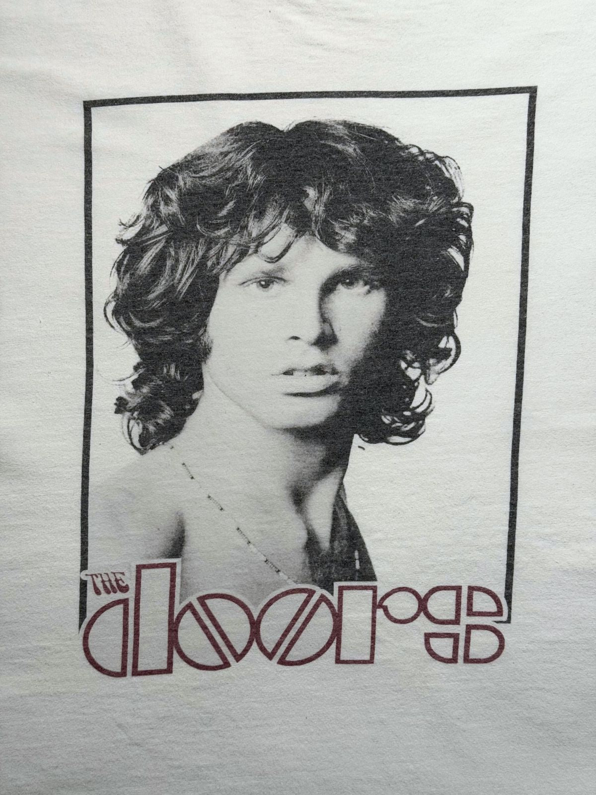 Detailansicht der vorderen Grafik: Schwarz-Weiß-Porträt von Frontmann Jim Morrison im Rechteck-Rahmen mit dem typischen „THE DOORS“-Schriftzug.