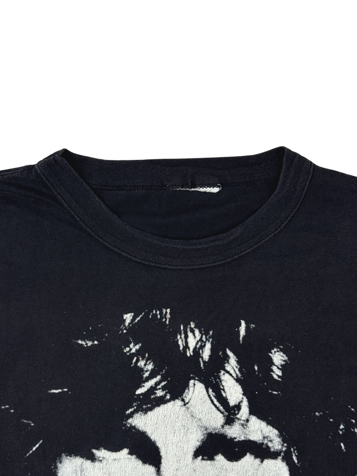 Detailaufnahme des Rundhalsausschnitts auf der Vorderseite des verwaschenen Classic-Rock-Shirts mit Blick auf ein stark beschädigtes Nackenetikett.