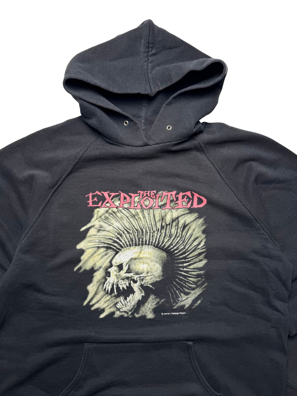 Detailansicht der vorderen Brustpartie mit Kapuze, Metallösen und dem ikonischen Siebdruck-Motiv aus Irokesen-Totenkopf und rotem „THE EXPLOITED“-Schriftzug.