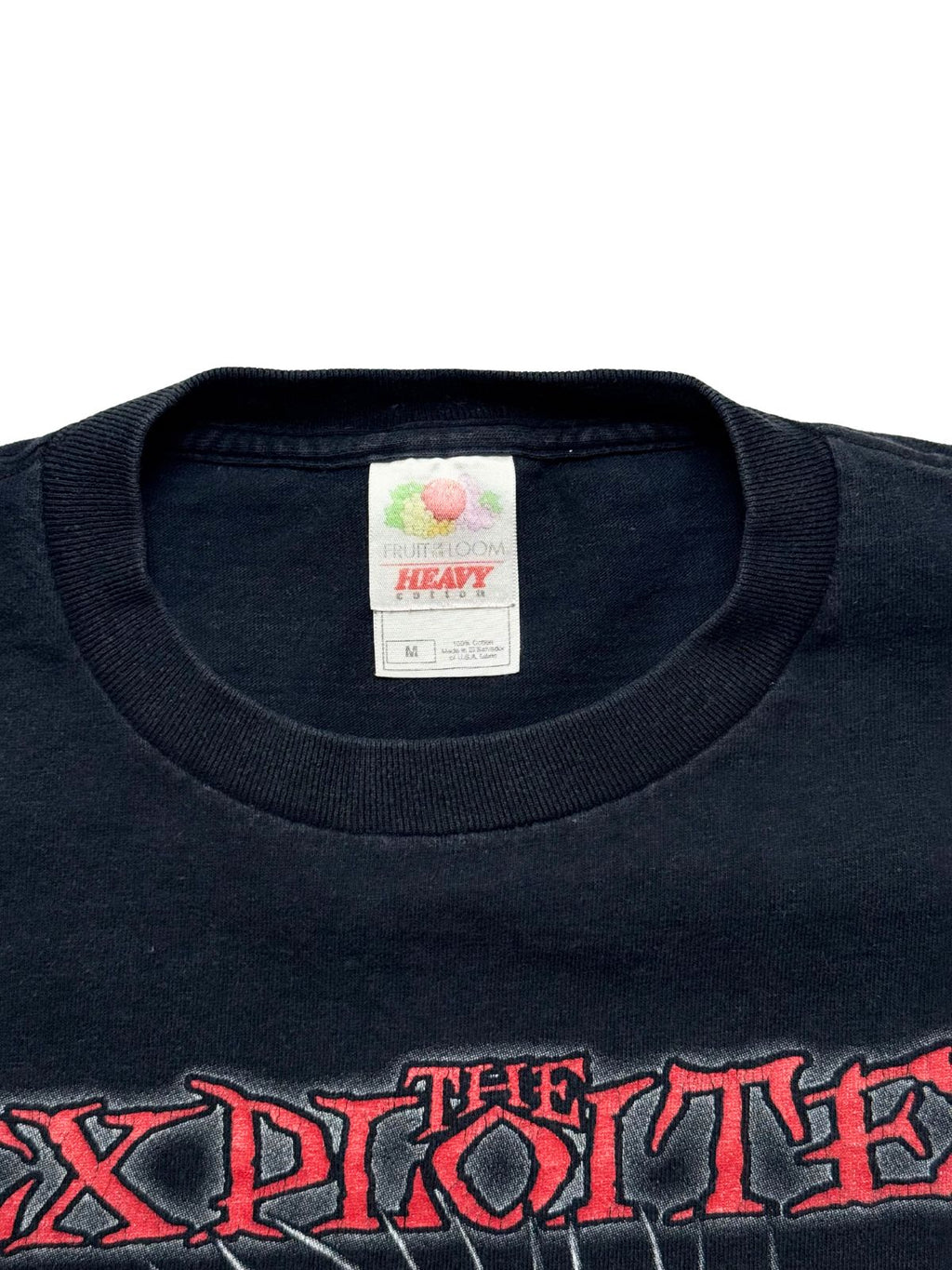Nahaufnahme des Kragens mit dem originalen weißen Nackenetikett der Marke „Fruit of the Loom HEAVY cotton“ (Größe M) oberhalb des roten Bandlogos.