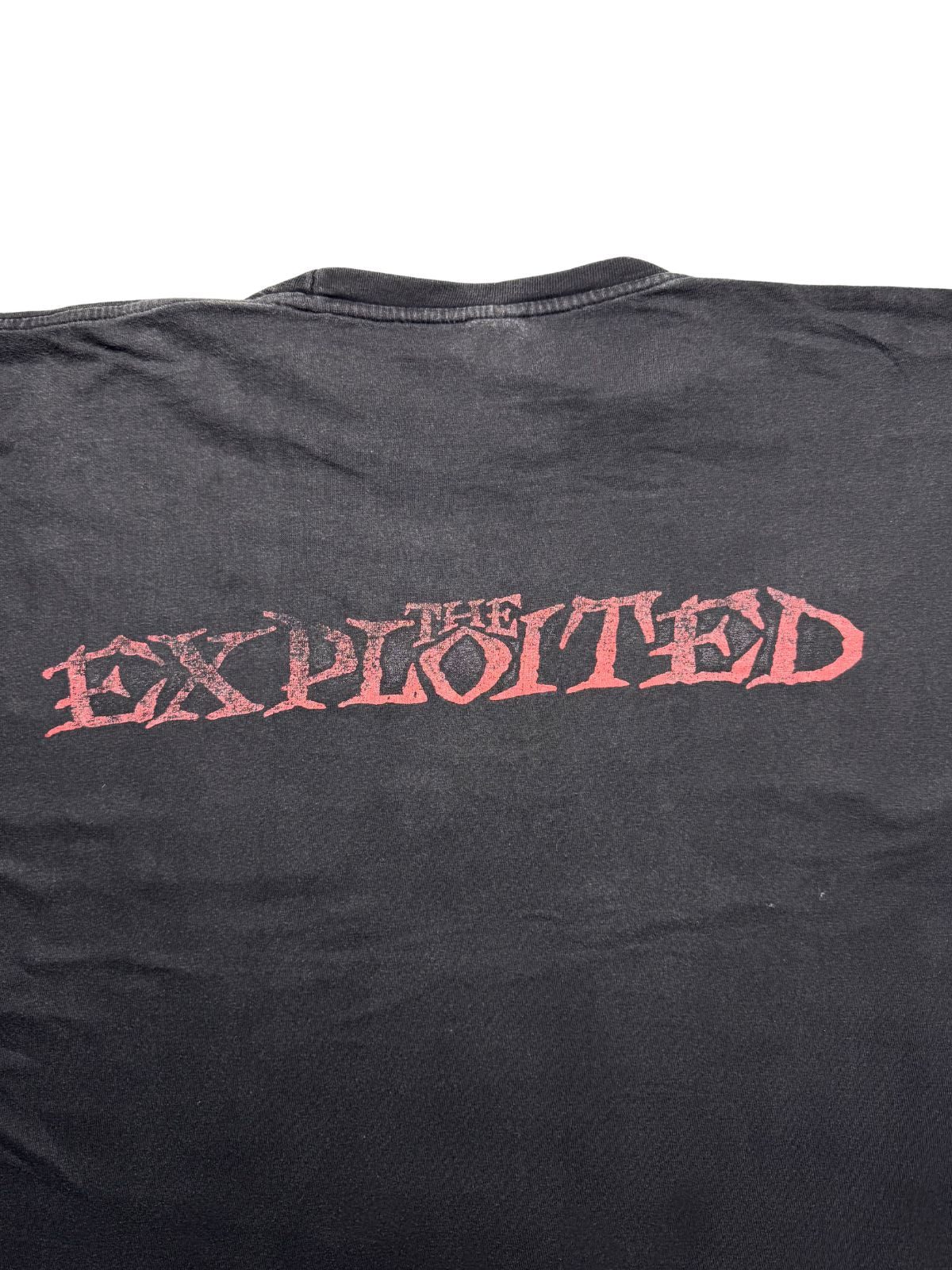 Detailansicht der oberen Rückseite mit Fokus auf die Nackennaht und den roten „THE EXPLOITED“-Backprint auf verwaschener Baumwolle.