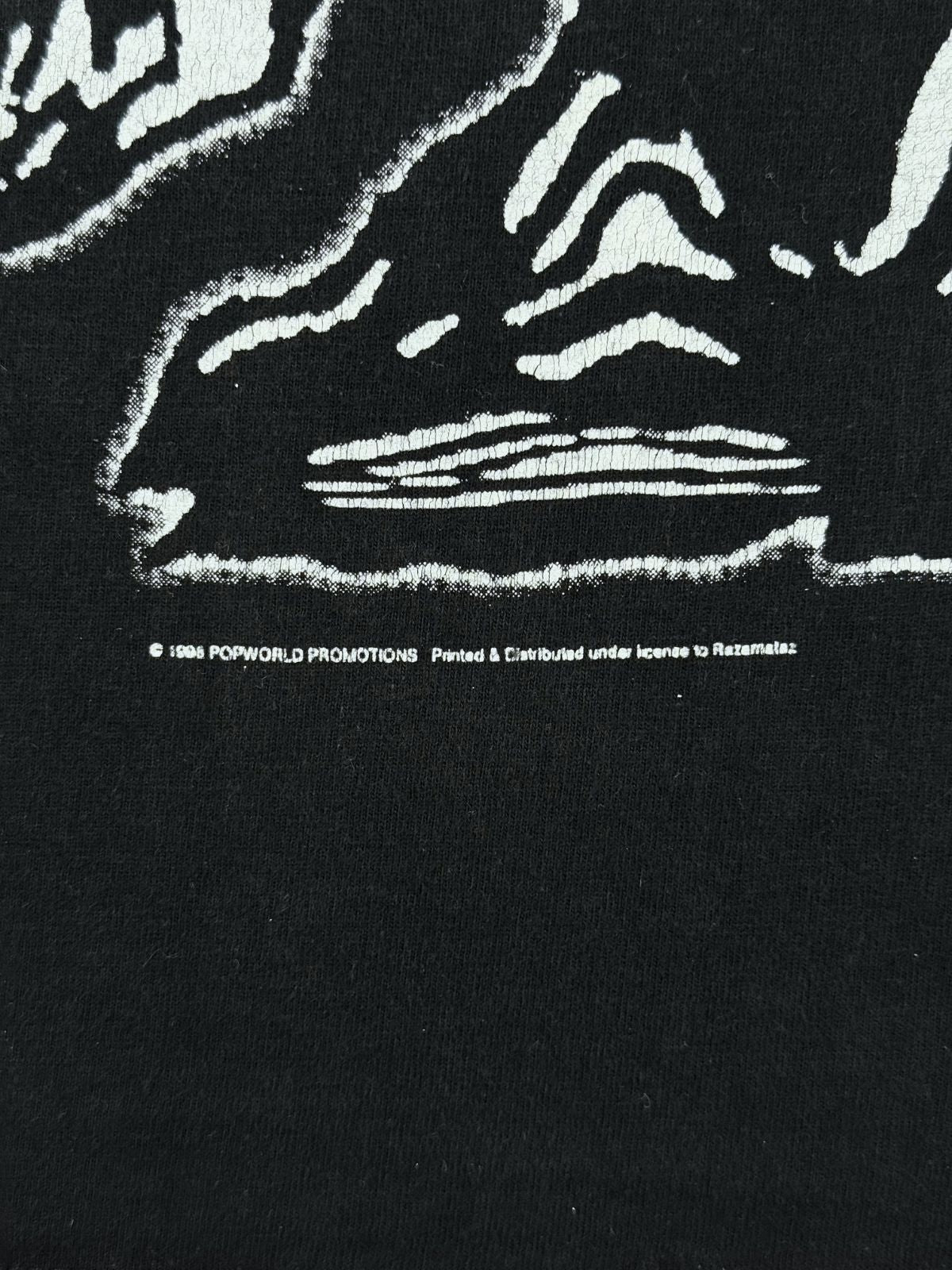 Makroaufnahme der Lizenzzeile unter dem Frontprint: „© 1998 POPWORLD PROMOTIONS - Printed & Distributed under license to Razamataz“.