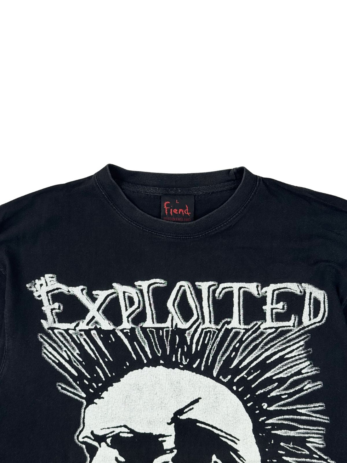 Nahaufnahme der oberen Vorderseite des Bandshirts mit Blick auf den gerippten Rundhalsausschnitt, das schwarze Fiend-Tag und den „THE EXPLOITED“-Schriftzug.