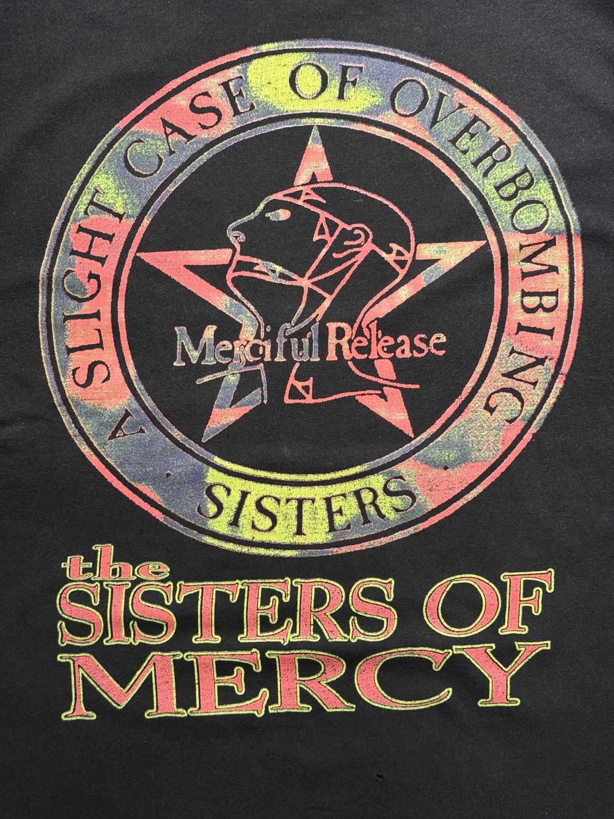 Detailansicht des vorderen Grafikprints mit dem bunten Stern-und-Kopf-Logo der Plattenfirma Merciful Release und dem „A Slight Case of Overbombing“-Schriftzug.