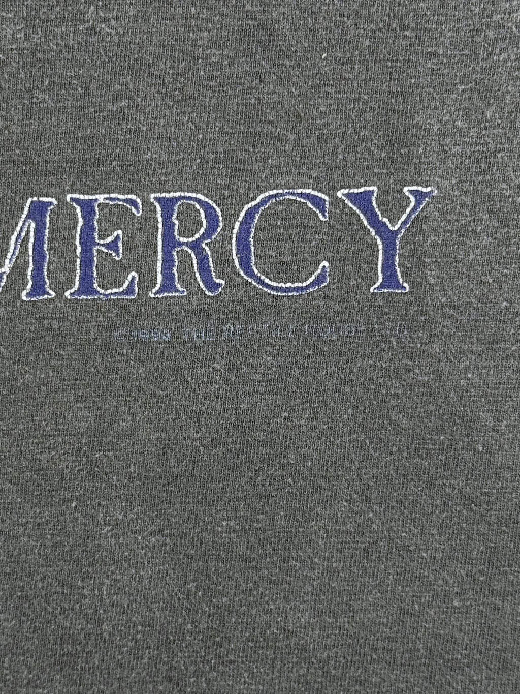 Nahaufnahme des Copyright-Vermerks unter dem Sisters of Mercy Print, Beleg für die Authentizität des 1993er Merchandises.
