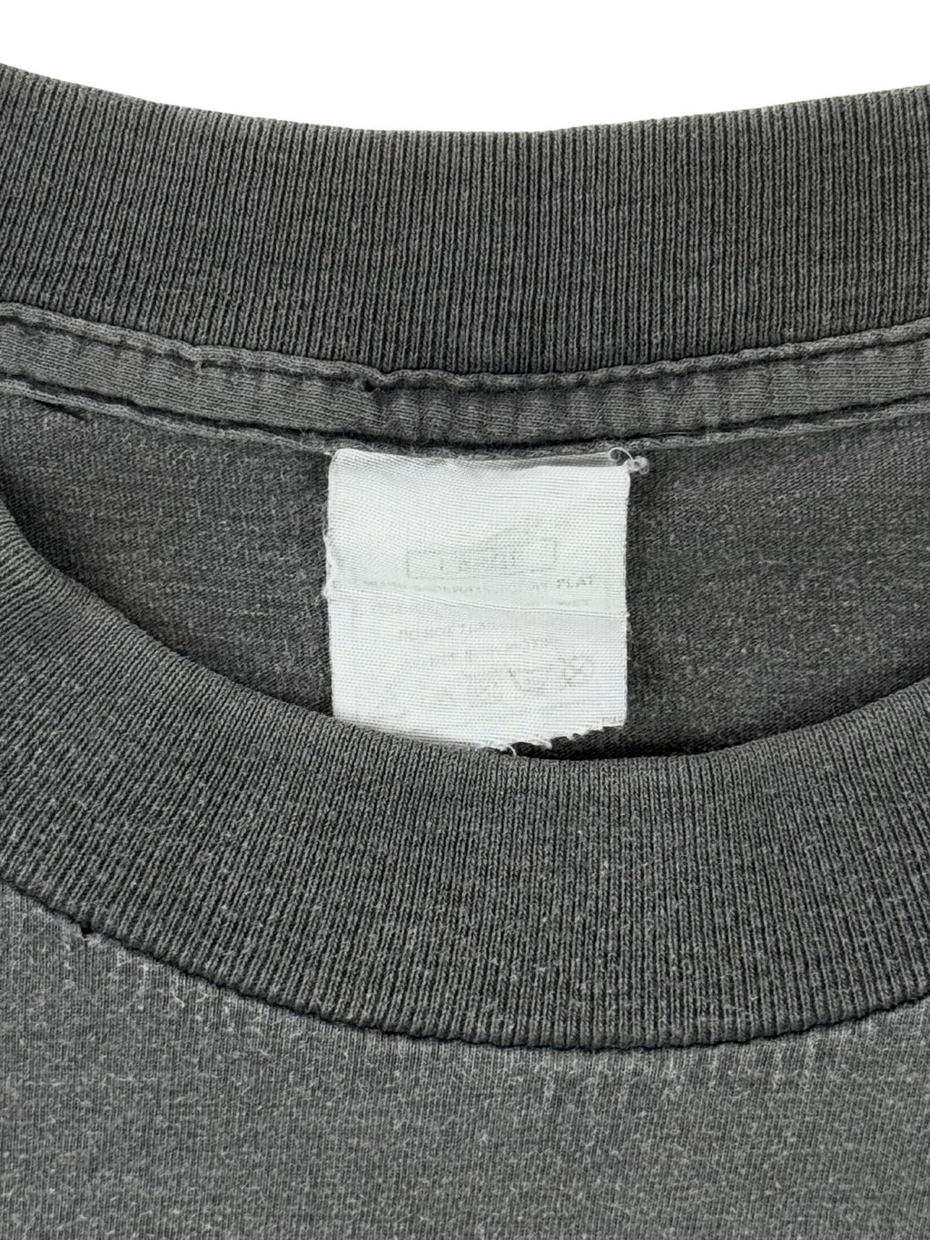 Verwaschenes Etikett (Neck Tag) im Kragen des Sisters of Mercy Vintage-T-Shirts, zeigt die authentische Altersstruktur des Textils.