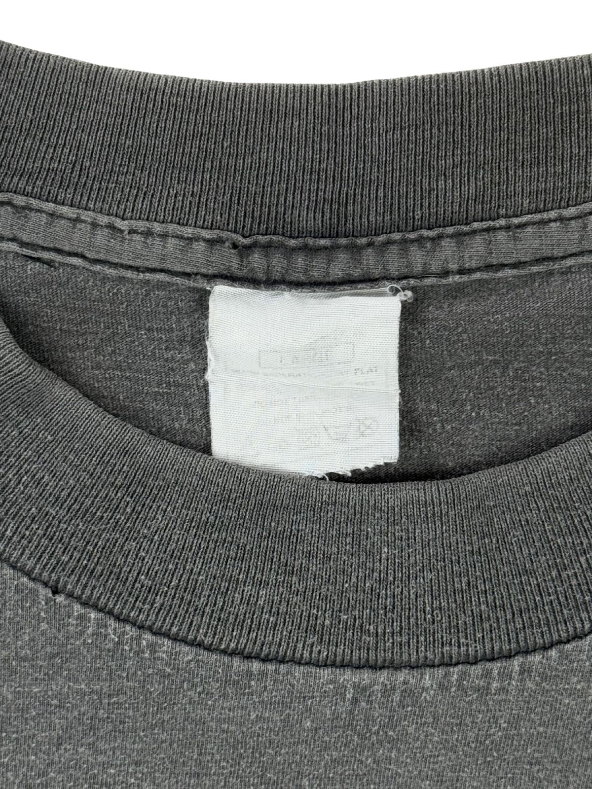Verwaschenes Etikett (Neck Tag) im Kragen des Sisters of Mercy Vintage-T-Shirts, zeigt die authentische Altersstruktur des Textils.