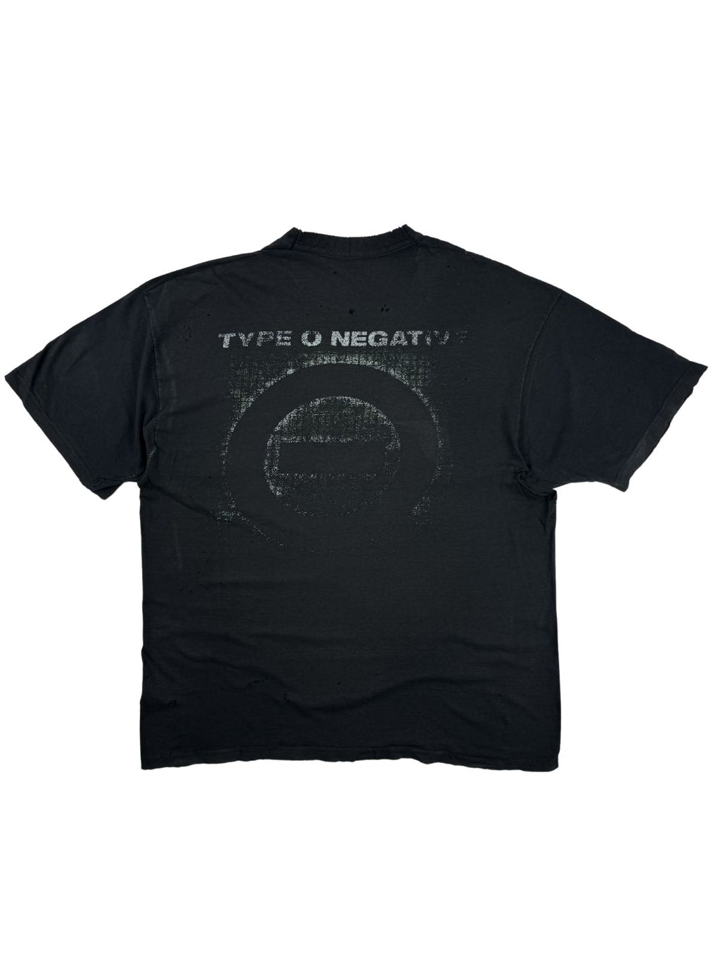 Rückansicht des verwaschenen Type O Negative Vintage-Shirts im Flatlay mit rissigem, weiß-grünem Backprint (Bandname und das ikonische Kreis-Logo). Der obere Schulterbereich weist zahlreiche kleine Löcher auf.