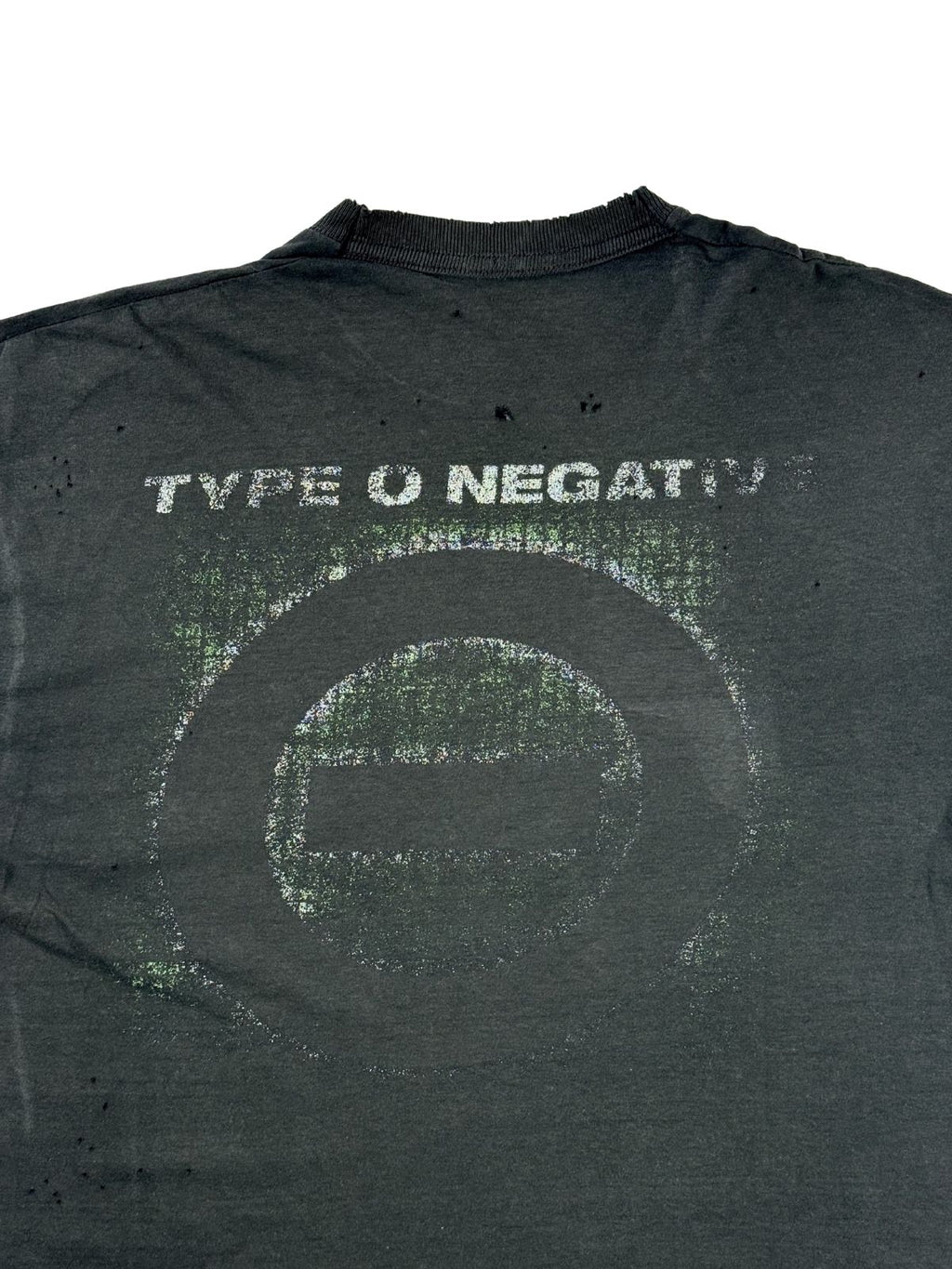Detailansicht des rissigen Grafikprints auf dem Rücken mit dem Type O Negative Band-Logo und Slogan. Über und neben dem kreisrunden Aufdruck befinden sich mehrere kleine Löcher im verwaschenen Stoff.