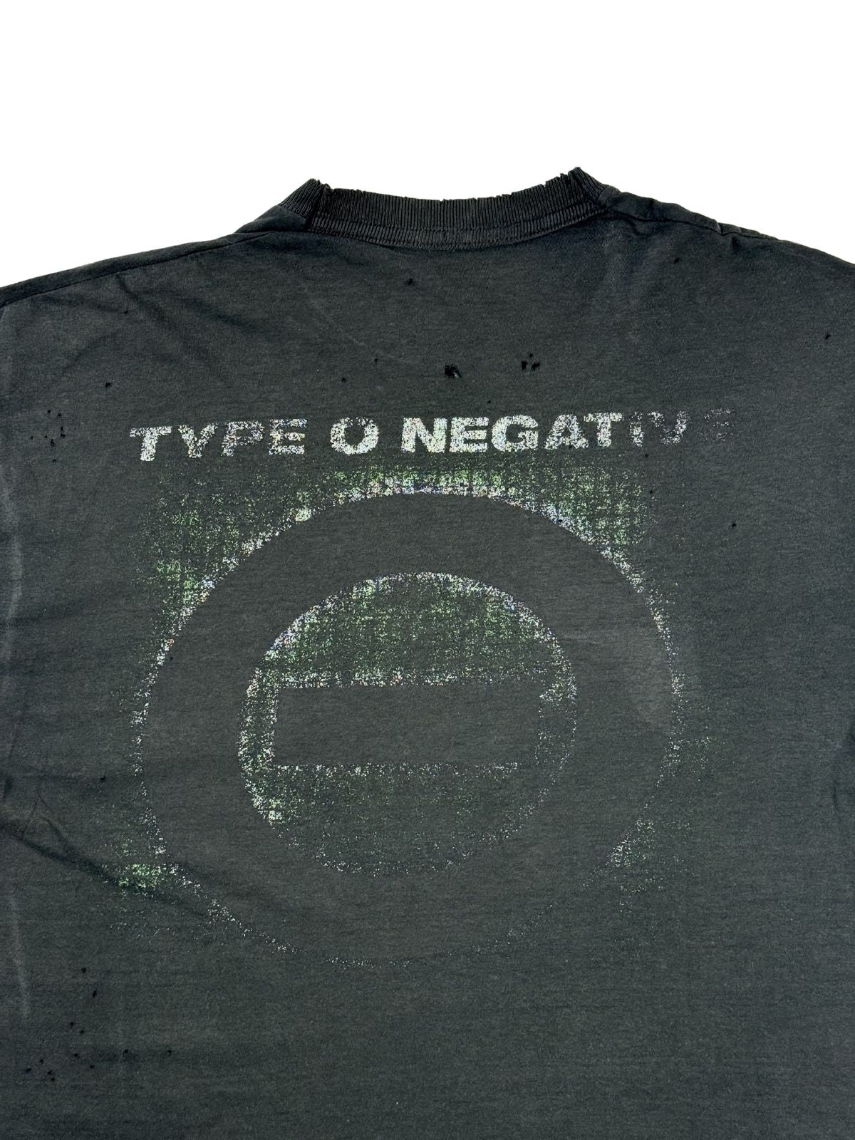 Detailansicht des rissigen Grafikprints auf dem Rücken mit dem Type O Negative Band-Logo und Slogan. Über und neben dem kreisrunden Aufdruck befinden sich mehrere kleine Löcher im verwaschenen Stoff.