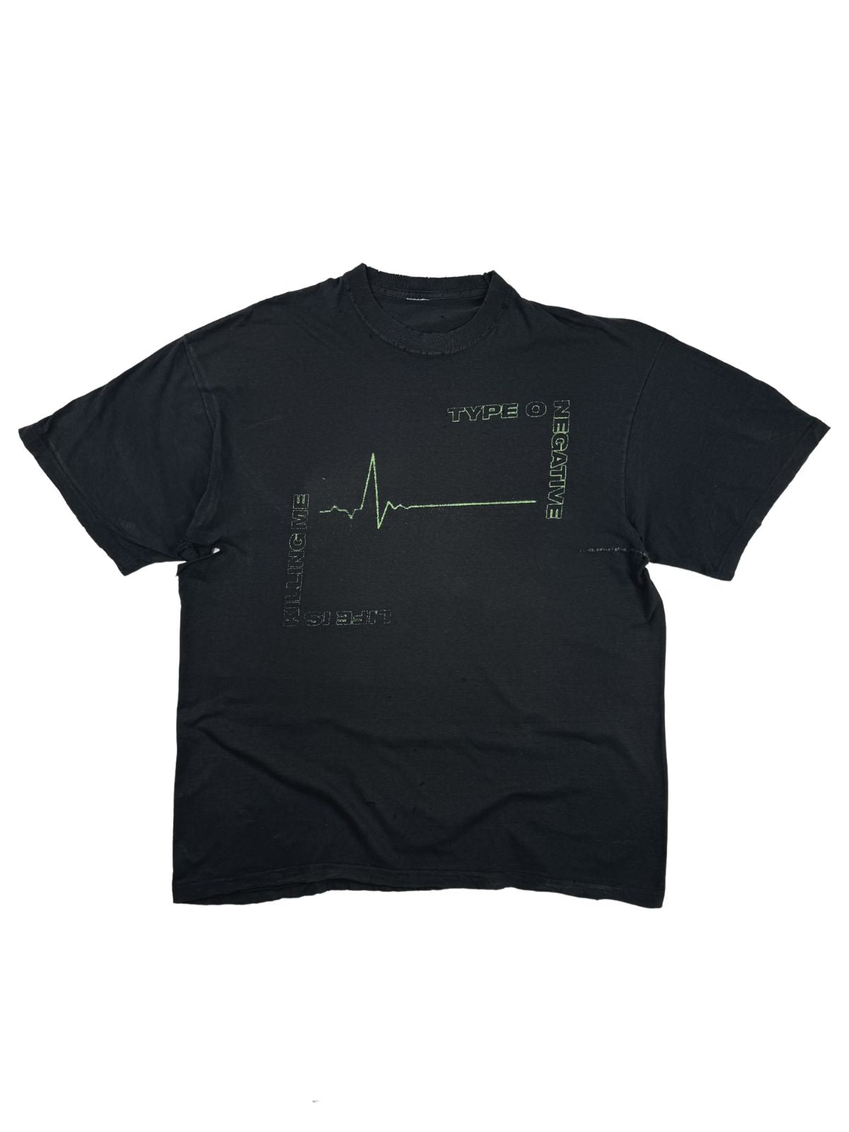 Komplettansicht der Vorderseite eines thrashed Vintage Type O Negative Band-Shirts zum Album „Life Is Killing Me“ aus dem Jahr 2003. Das schwarze, stark verwaschene T-Shirt zeigt eine grüne EKG-Linie als Frontprint. Flatlay auf weißem Hintergrund.
