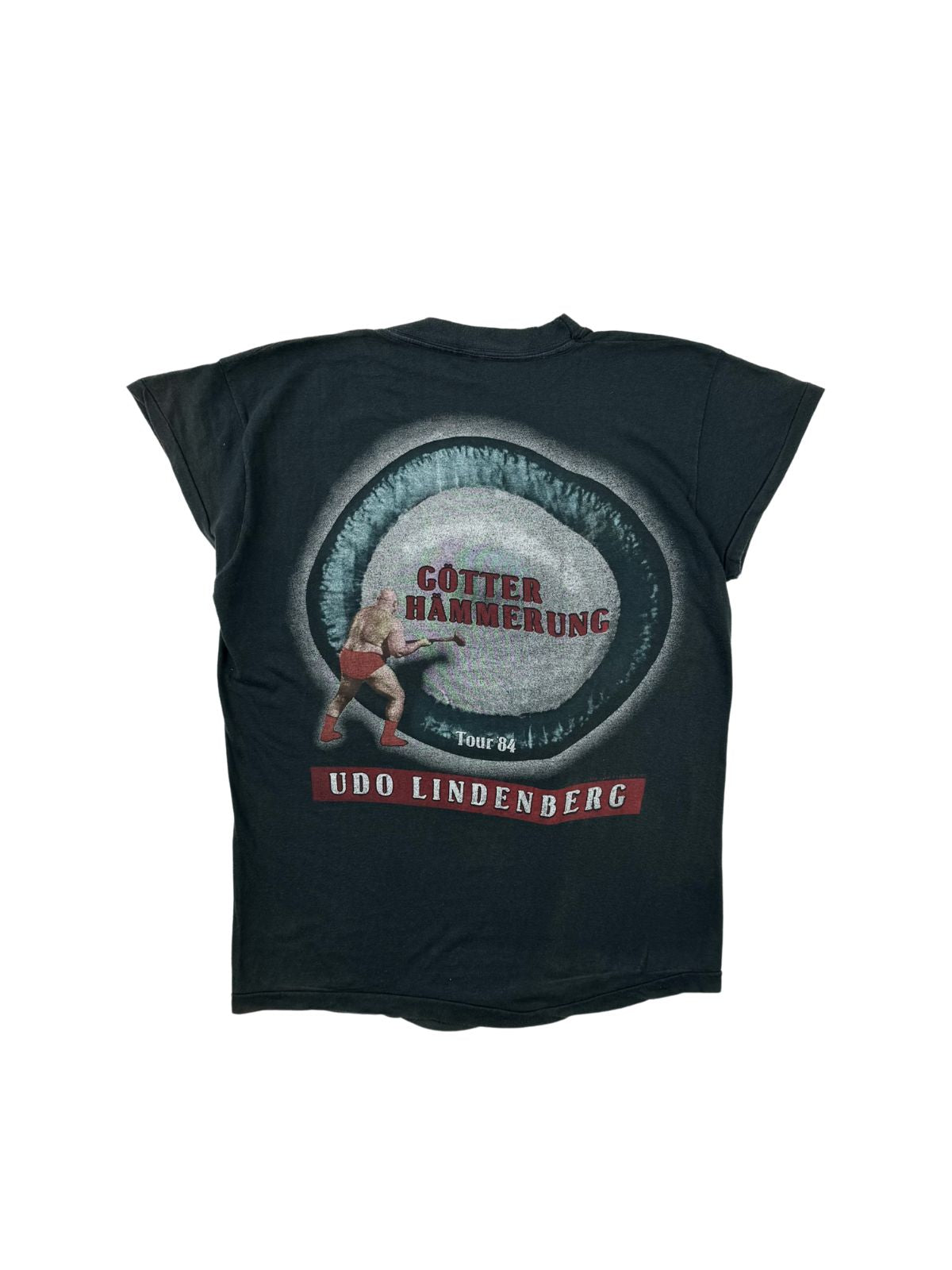 Rückseite des 1984er Udo Lindenberg Tour-Shirts mit farbigem „Götterhämmerung Tour '84“-Grafikprint, der einen Mann mit einem Vorschlaghammer in roter Unterhose zeigt.