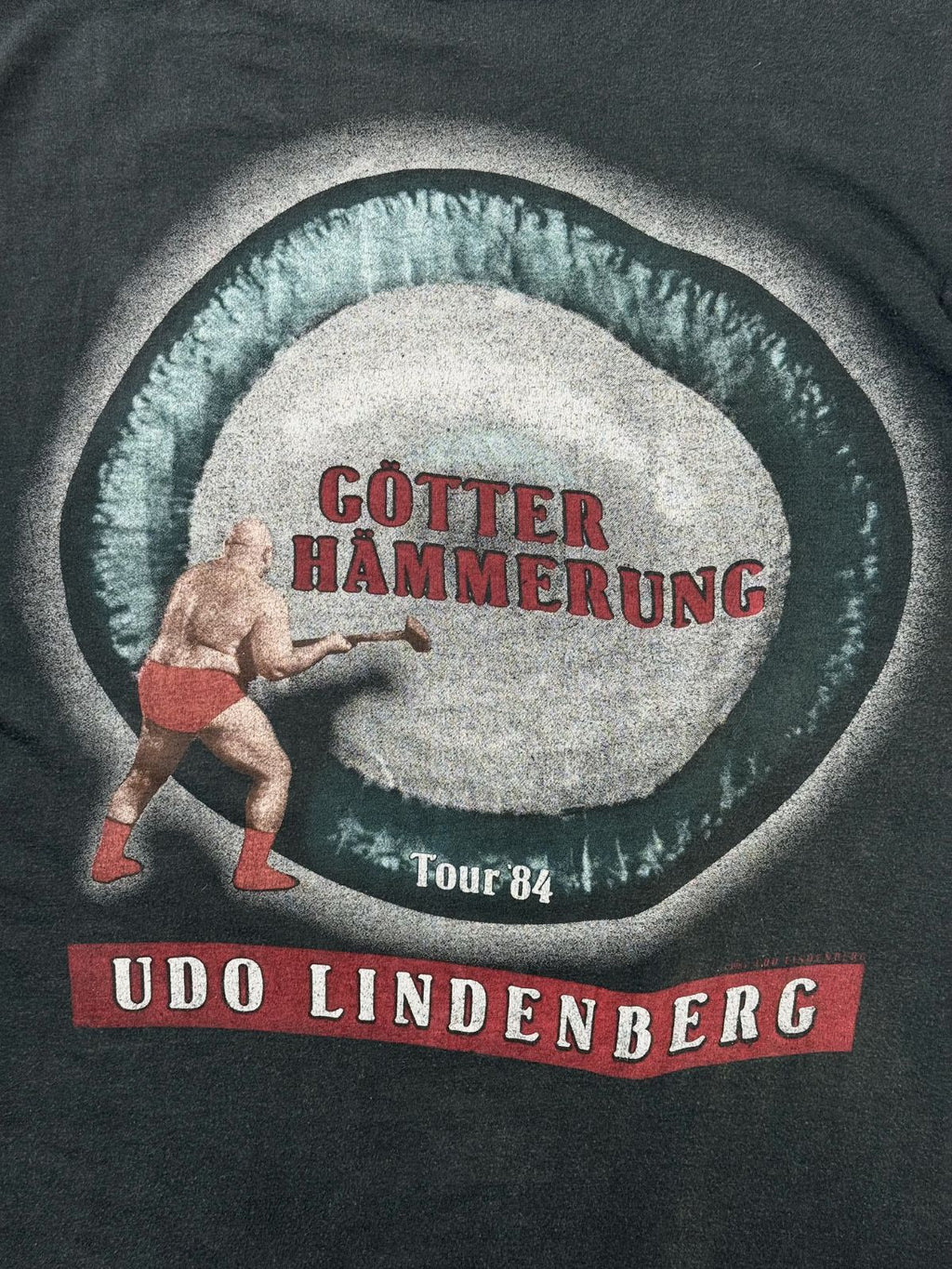 Detaillierte Nahaufnahme des kreisrunden Backprints mit den Schriftzügen „GÖTTER HÄMMERUNG Tour '84“ und dem roten „UDO LINDENBERG“-Banner.