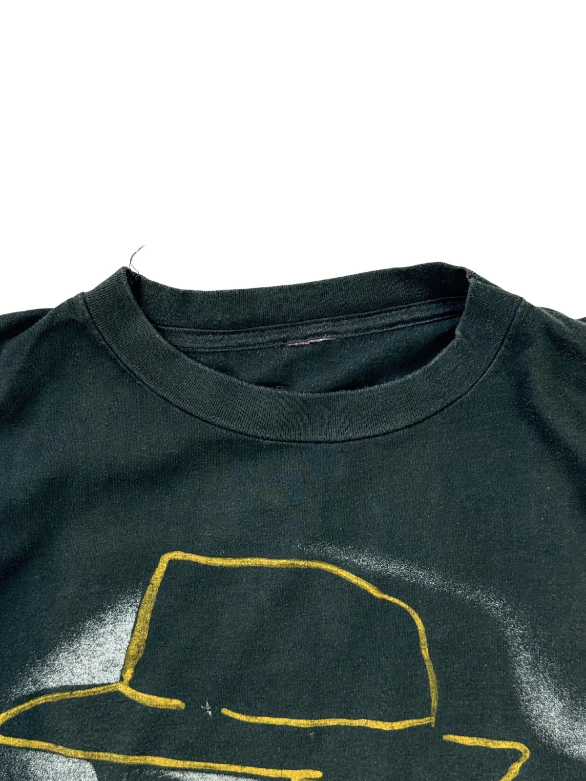 Nahaufnahme des Rundhalsausschnitts auf der Vorderseite des verwaschenen, schwarzen Deutschrock-Shirts direkt über der gelben Hut-Kontur.