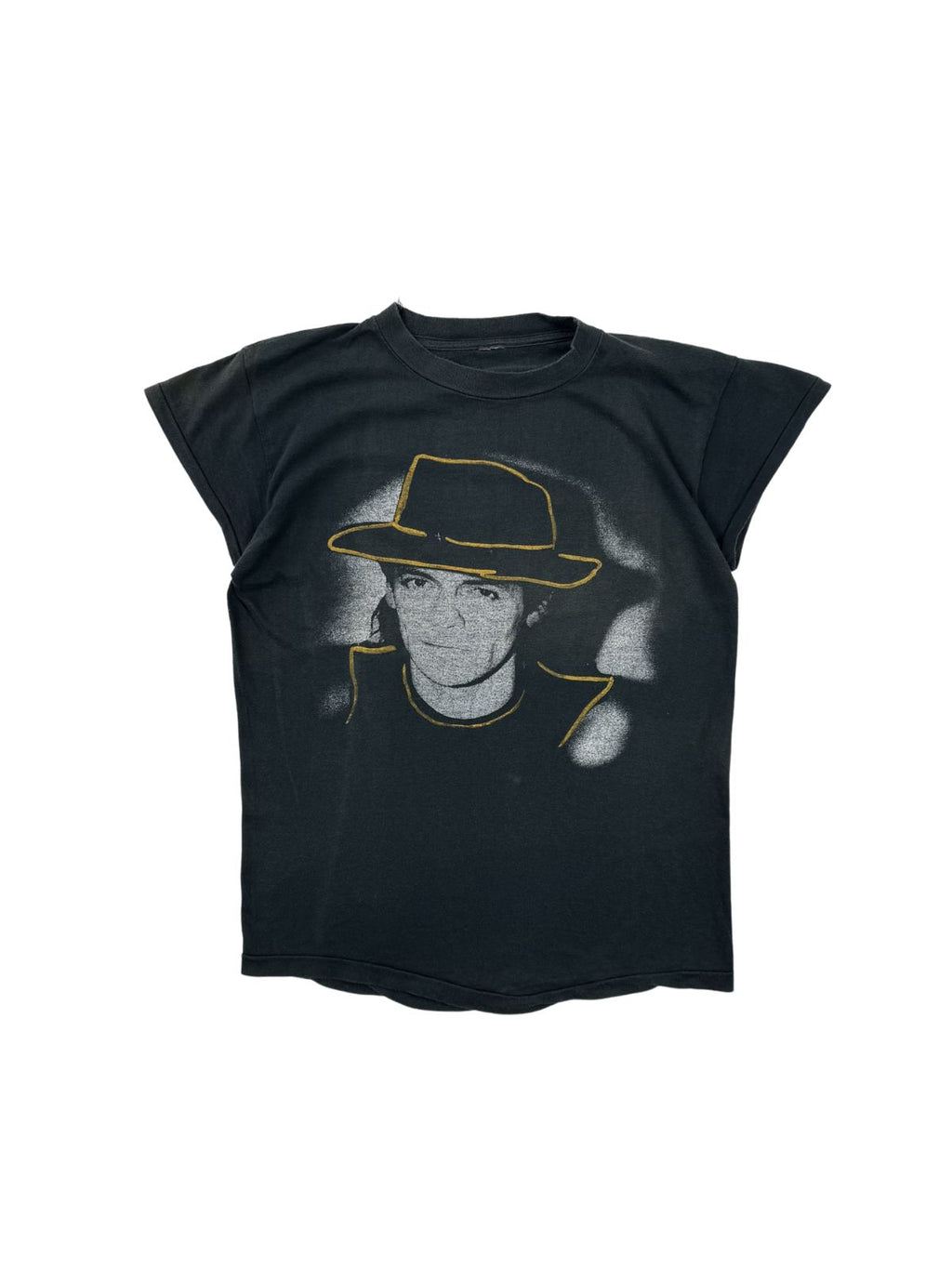Originales Vintage Udo Lindenberg T-Shirt zur „Götterhämmerung“ Tour 1984. Schwarzes Krautrock-Bandshirt in der Frontansicht mit einem großen Porträt-Print von Udo Lindenberg samt ikonischem Hut mit gelber Outline.