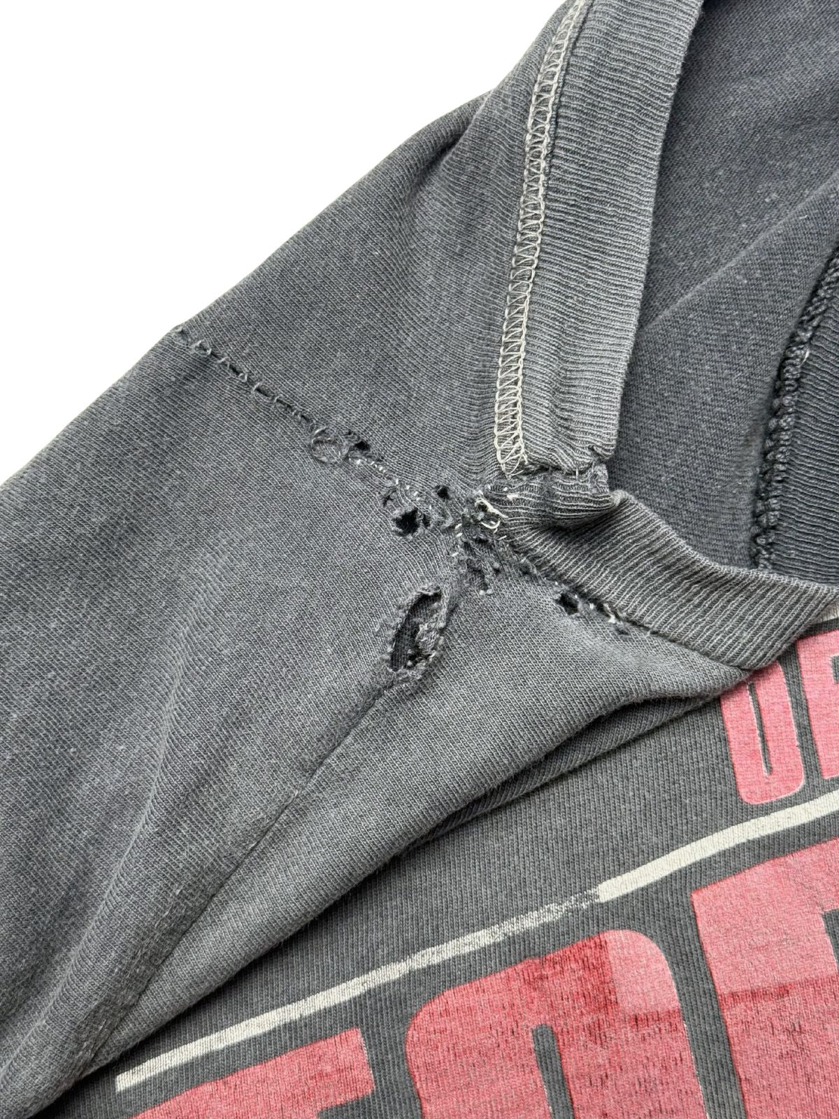 Nahaufnahme der Schulter- und Achselnaht mit reparierten Stellen, Zickzack-Stich und kleinen Löchern zur genauen Zustandsdokumentation.