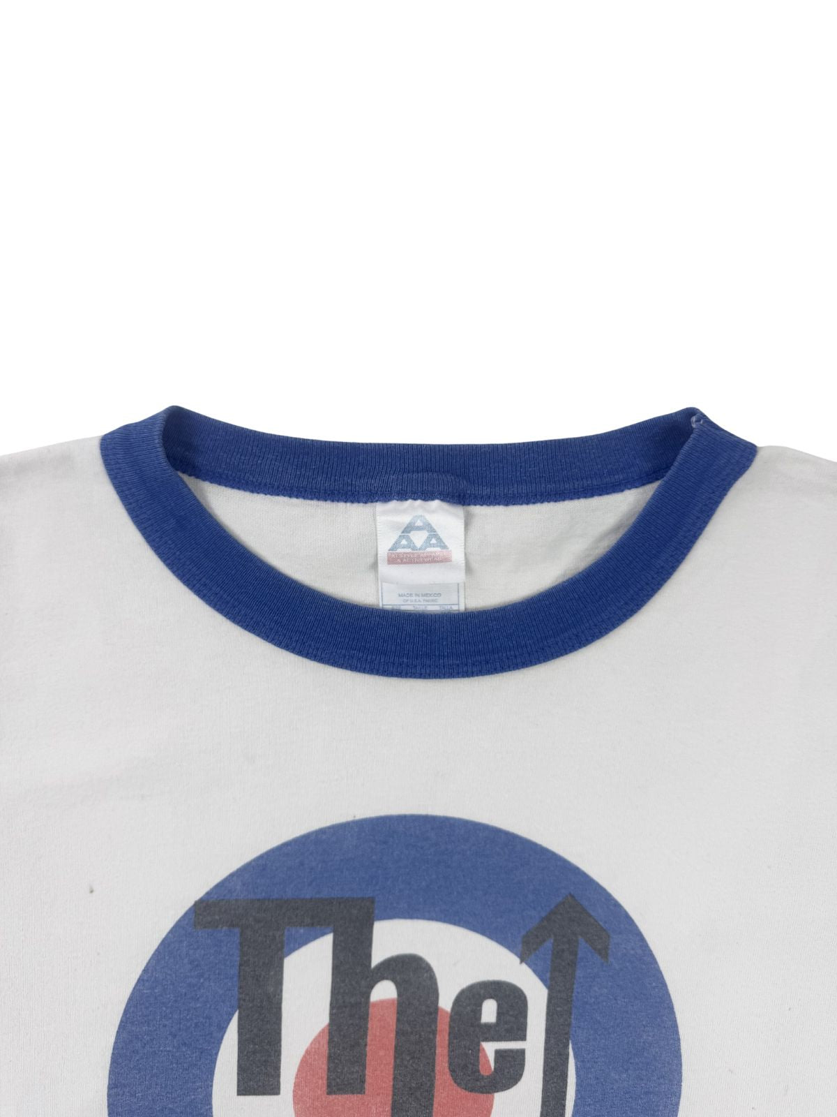 Fokus auf das Nackenetikett: „AAA Alstyle Apparel & Activewear“, Made in Mexico, auf einem weißen Baumwoll-Ringer-Shirt.